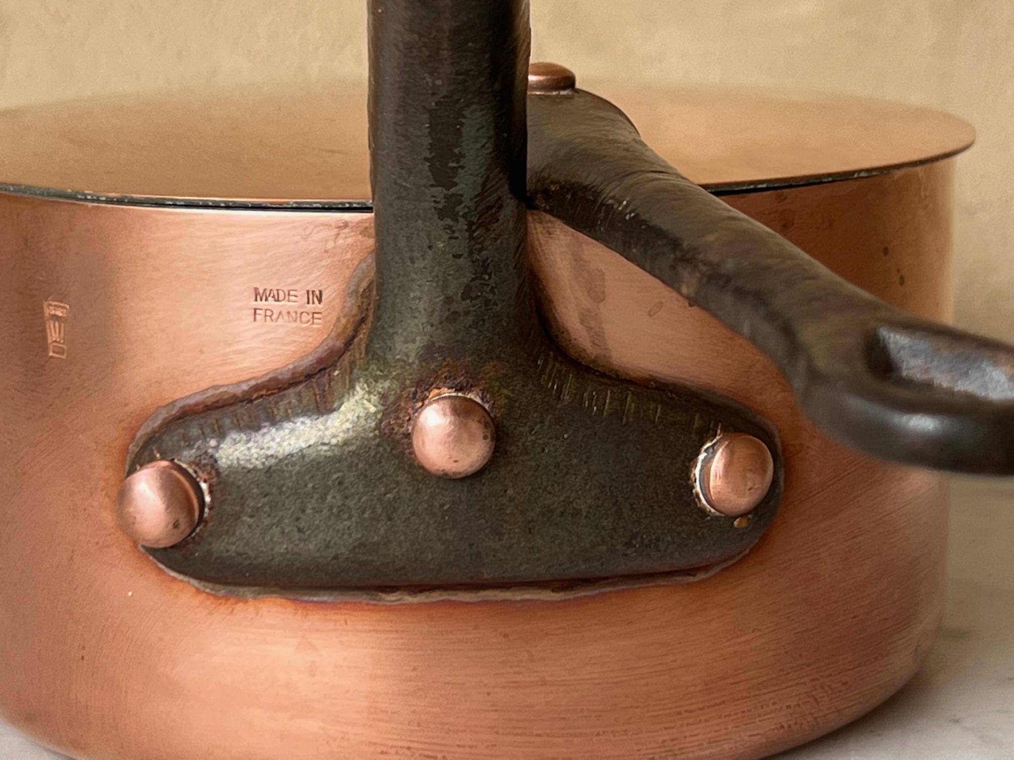 Vintage French copper professional 6.5 inch sauce pan and lid. The copper pot and handle have long cast iron handles with copper rivets and loops at the top for hanging each. Each piece has a layer of tin and ready to use.

The pan is stamped to
