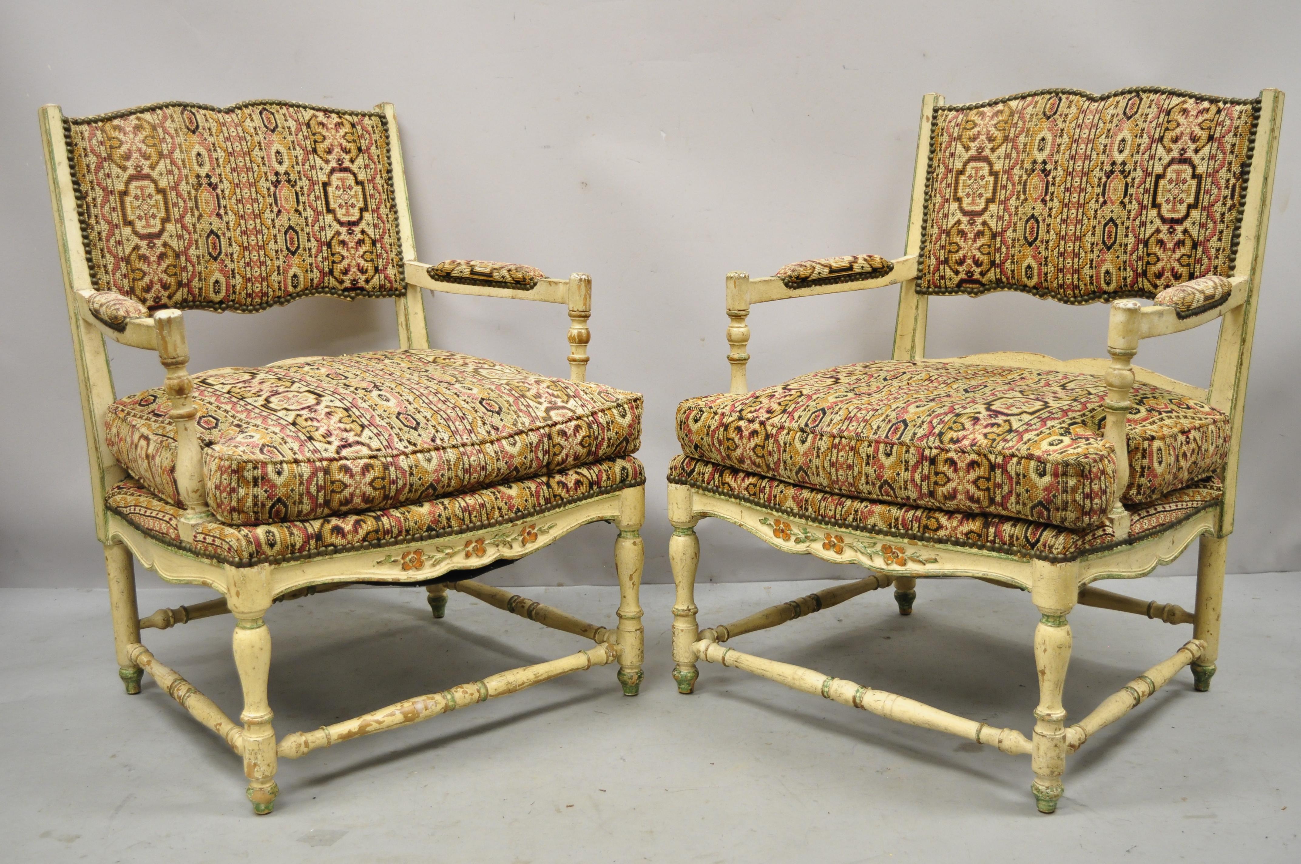 Pair of vintage French provincial cream distress painted lounge arm chairs and ottoman. Item features cream distress painted finish, (2) armchairs and (1) ottoman, ladderback, solid wood frames, nicely carved details, very nice vintage set, great