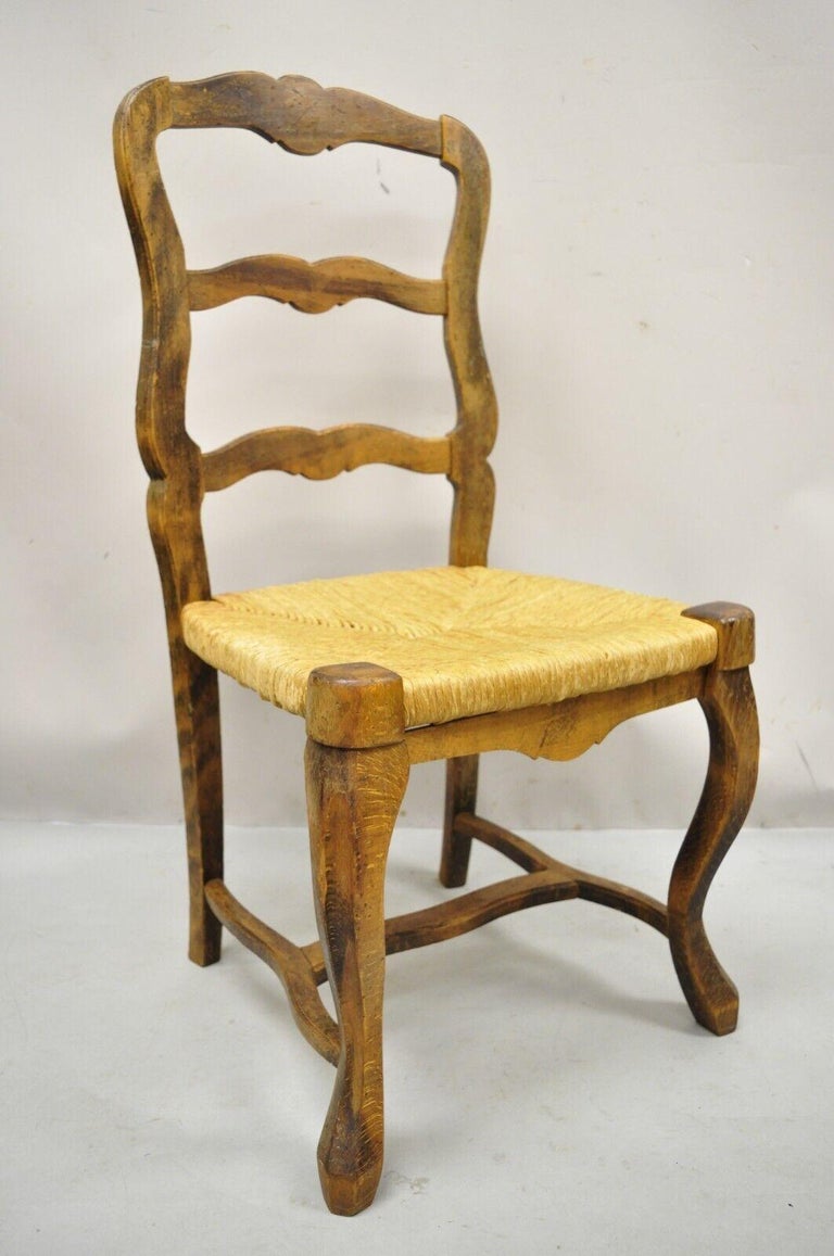 Vintage French provincial distressed wood ladder back rush seat dining side chair. Item features woven rush seat, stretcher base, ladder back, solid wood frame, beautiful wood grain, distressed finish, original stamp, quality Italian craftsmanship.