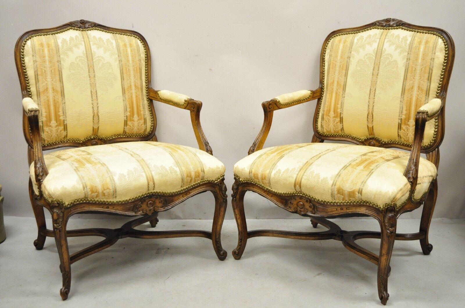 Vintage French Provincial Louis XV Country Style Lounge Chairs - a Pair. Item features a cross stretcher base, beige floral print upholstery, solid wood frames, upholstered armrests, distressed finish, cabriole legs, very nice vintage pair. Circa