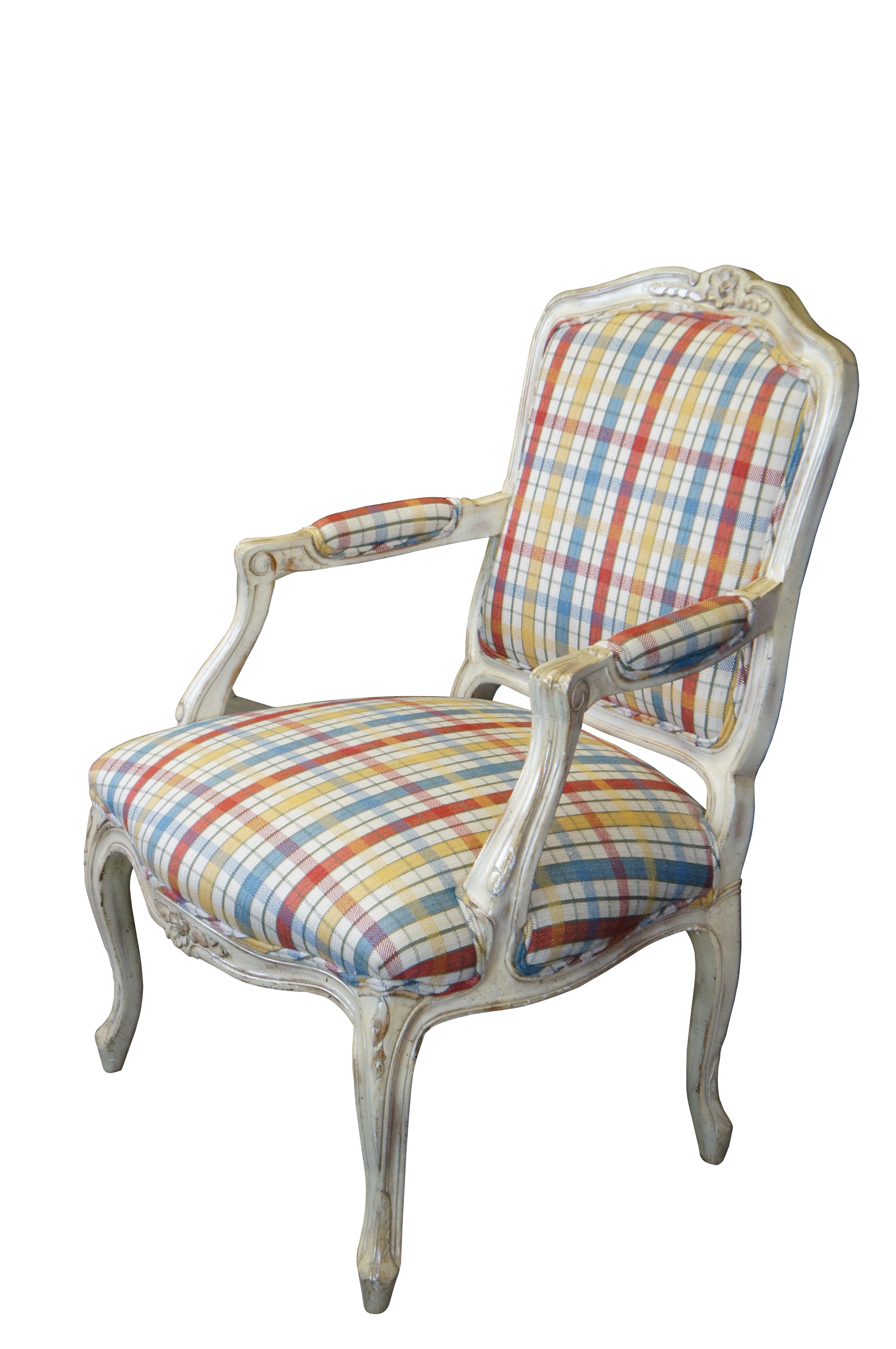Fauteuil vintage de style provincial français / Louis XV.  Fabriquée en noyer, elle présente des motifs floraux et serpentins sculptés, des accoudoirs en forme de fauteuil, un cadre peint en blanc et des pieds en cabriole.  Tapissé d'un tissu rouge,