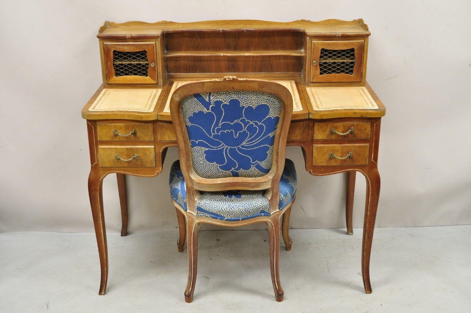Vintage French Provincial Louis XV Style vanity desk avec dessus en cuir, miroir et chaise latérale. Cet article est caractérisé par un fini lavé à la chaux, des accents floraux sculptés, un tissu à imprimé floral bleu, un couvercle rabattable avec