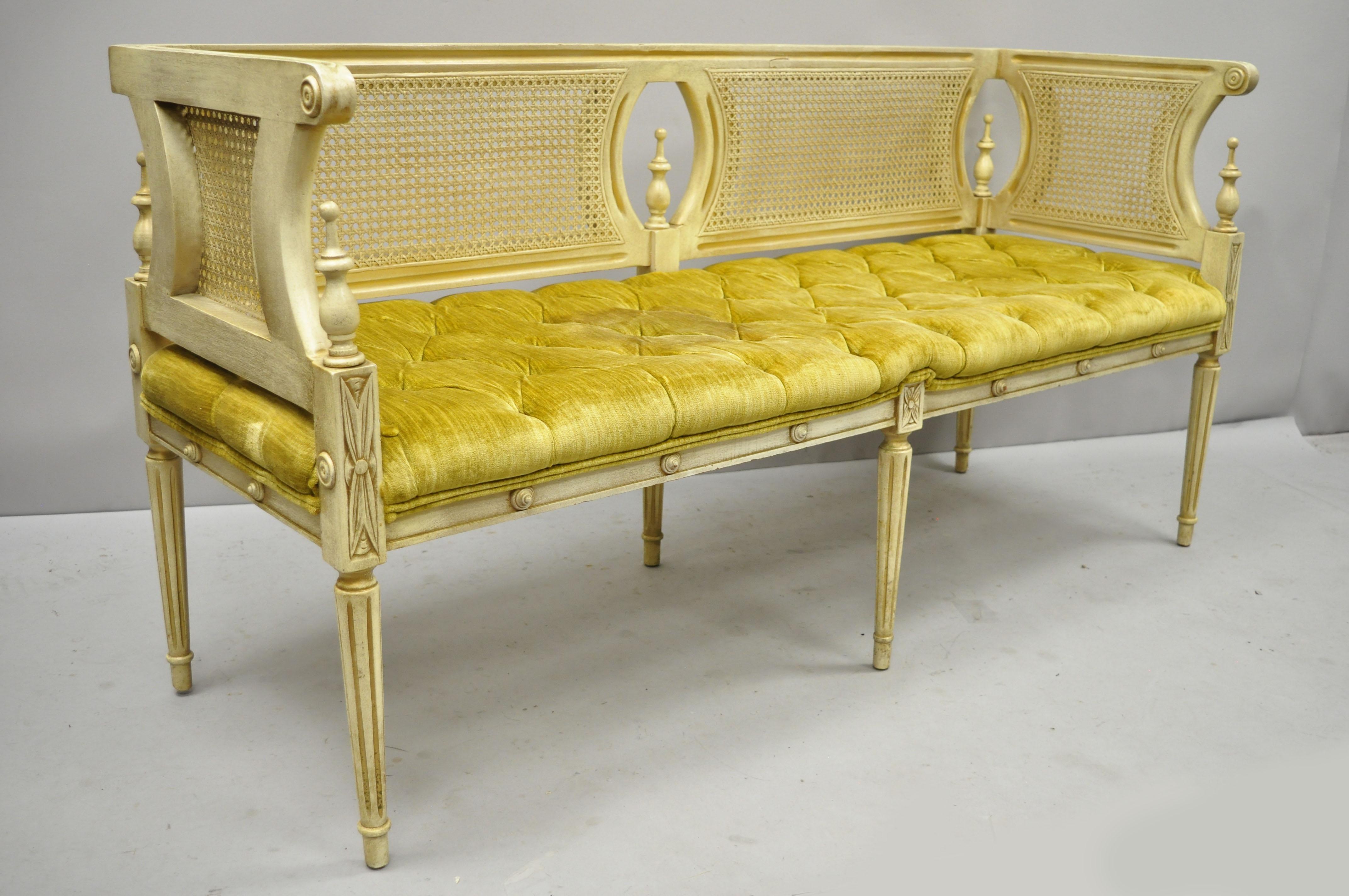 Vintage French provincial Louis XVI style cane back cream and gold bench settee. Item features cane, cream and gold painted finish, solid wood frame, nicely carved details, tapered legs, great style and form circa mid-20th century. Measurements: