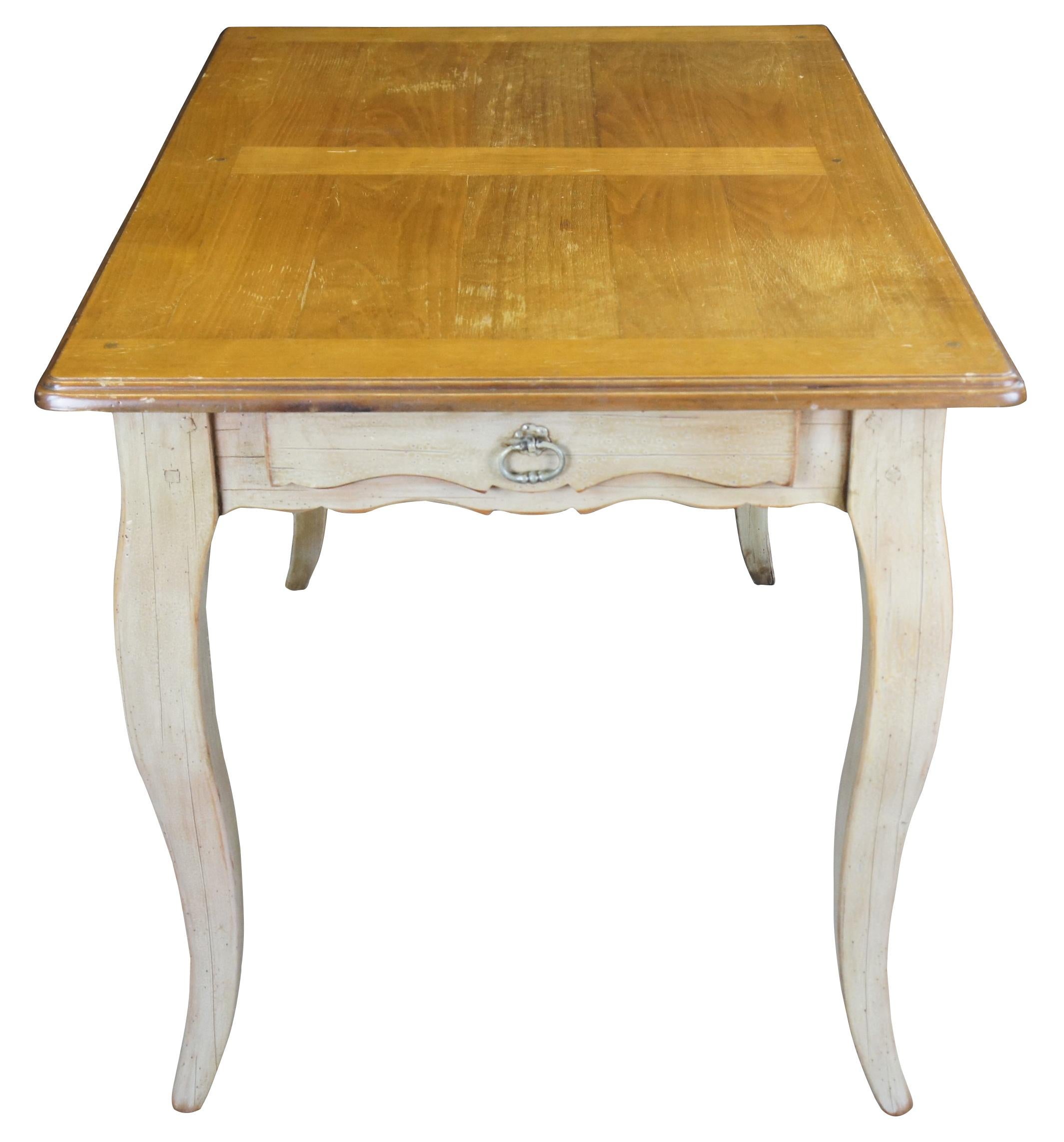 1980s Louis XV or Provincial inspired breakfast or dining table. Made from walnut with a washed base. Features a natural top over a serpentine cut apron, dovetailed drawer with brass hardware and cabriole legs. Measure: 45