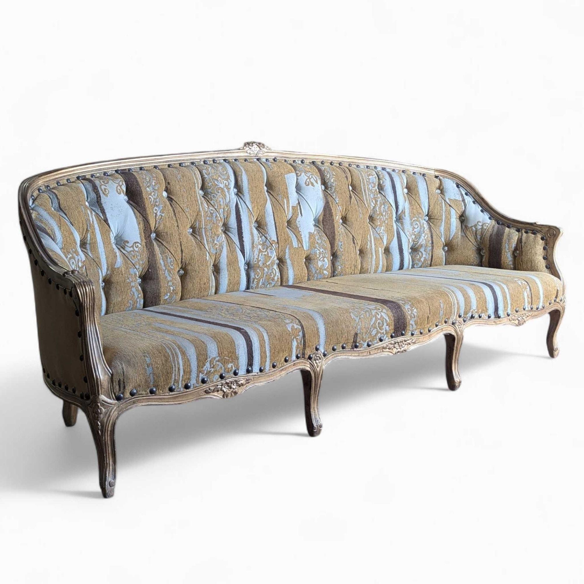 An elegant vintage sofa, re-upholstered in a vibrant striped fabric with tufted back detail and a carved wooden frame, featuring refined Louis XV style elements.

Traditional European Antique with Louis XV influences. The sofa showcases delicate