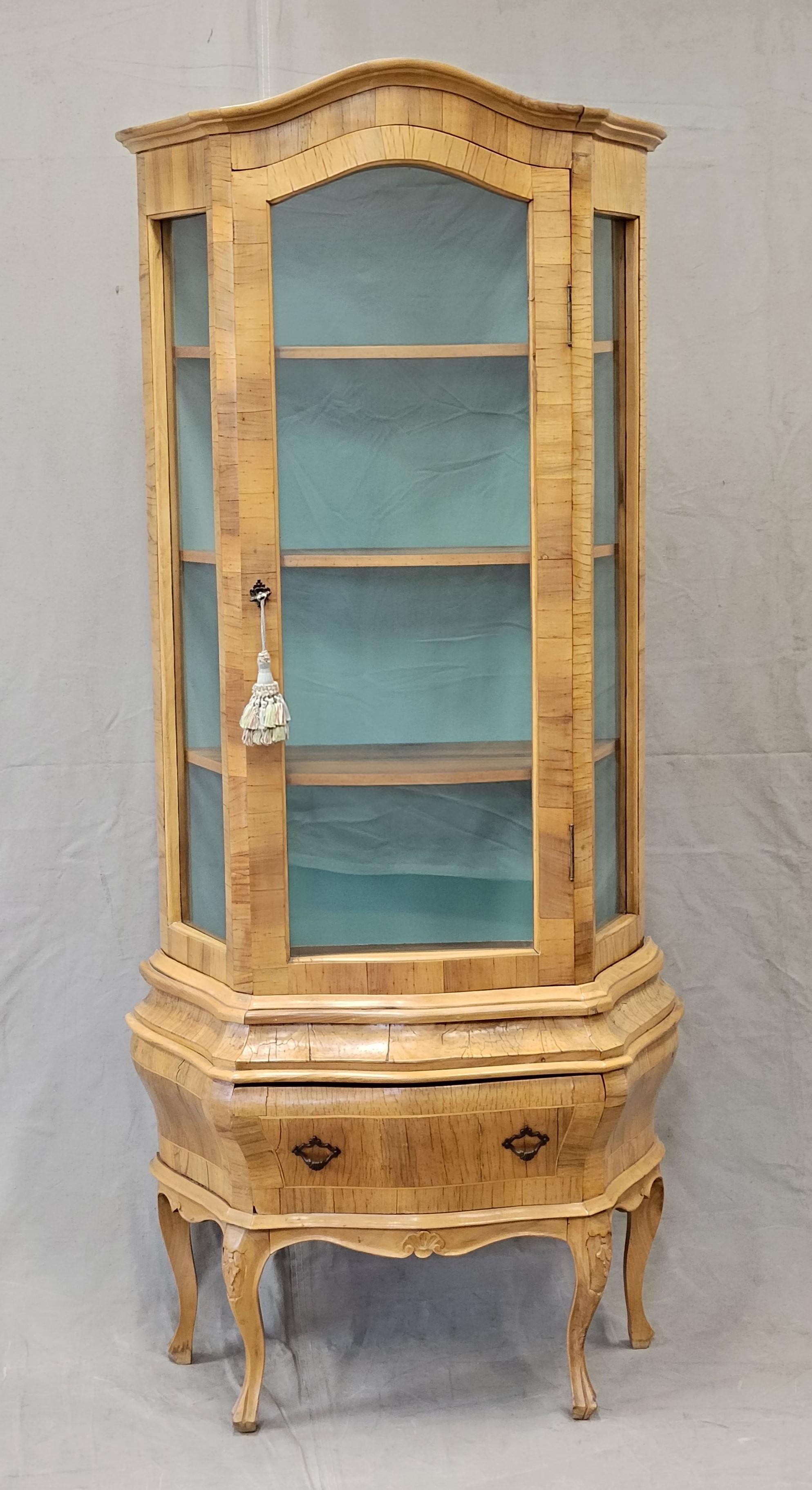 Beautiful French provincial display cabinet, perhaps from the 1960s. Light honey colored wood, perhaps ash, glows and background verdigris panel is a lovely contrast. Three removable wood shelves. Door closes and locks but due to time and shrinkage