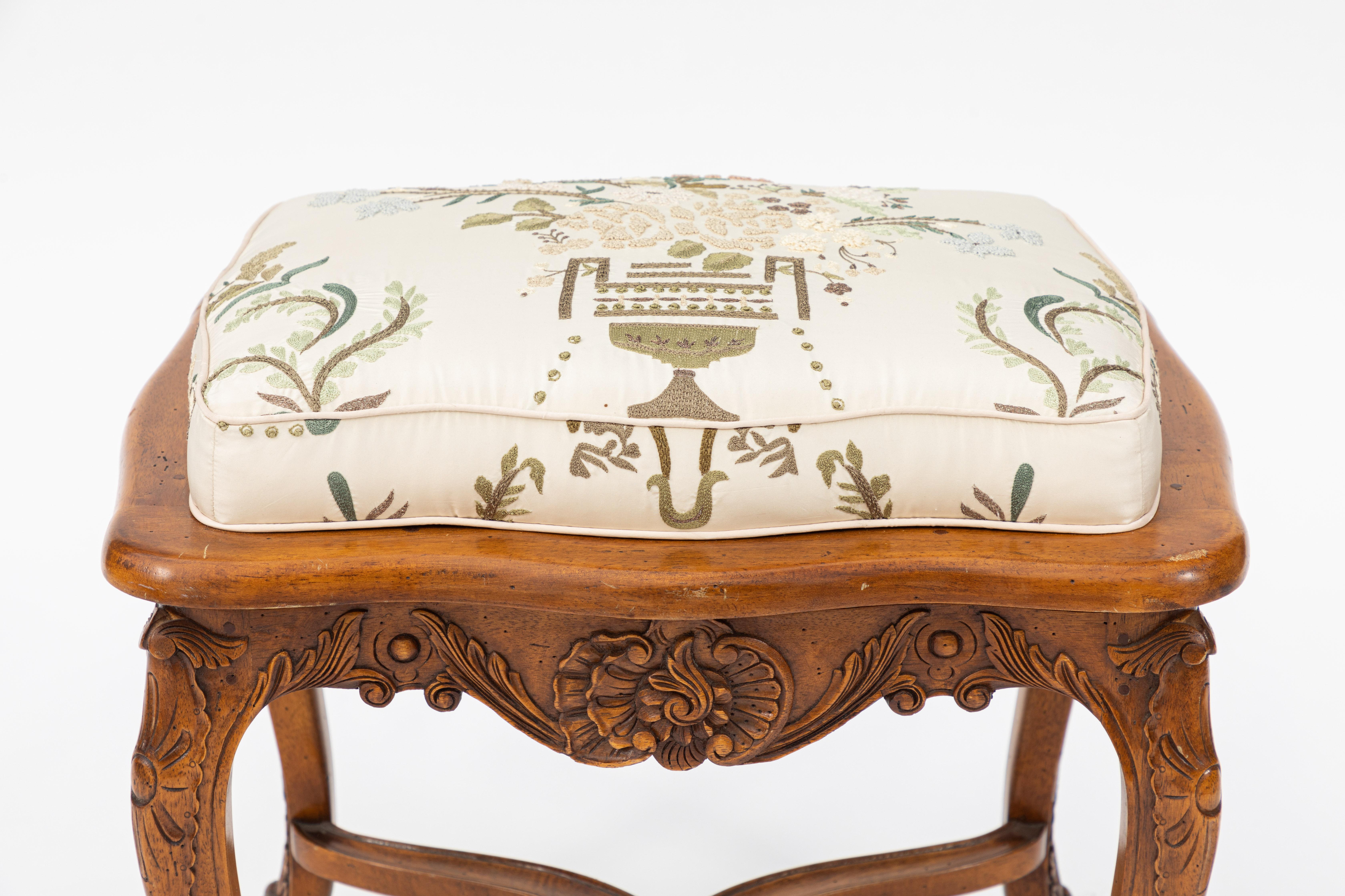 Vintage French provincial walnut bench upholstered in embroidered silk fabric in floral urn motif.