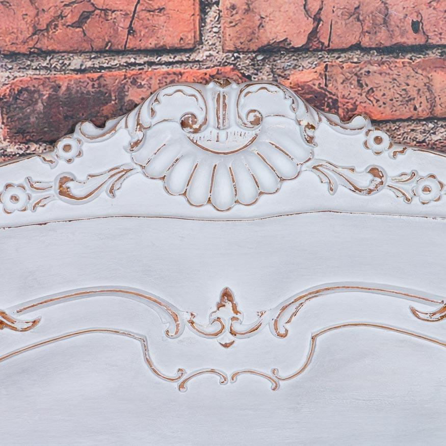 Romantic and feminine, this Queen size headboard is filled with French style and charm. The headboard has a combination of applied and hand carving that gracefully compliments the Rococo style. Recently painted a cool off white color, the paint has
