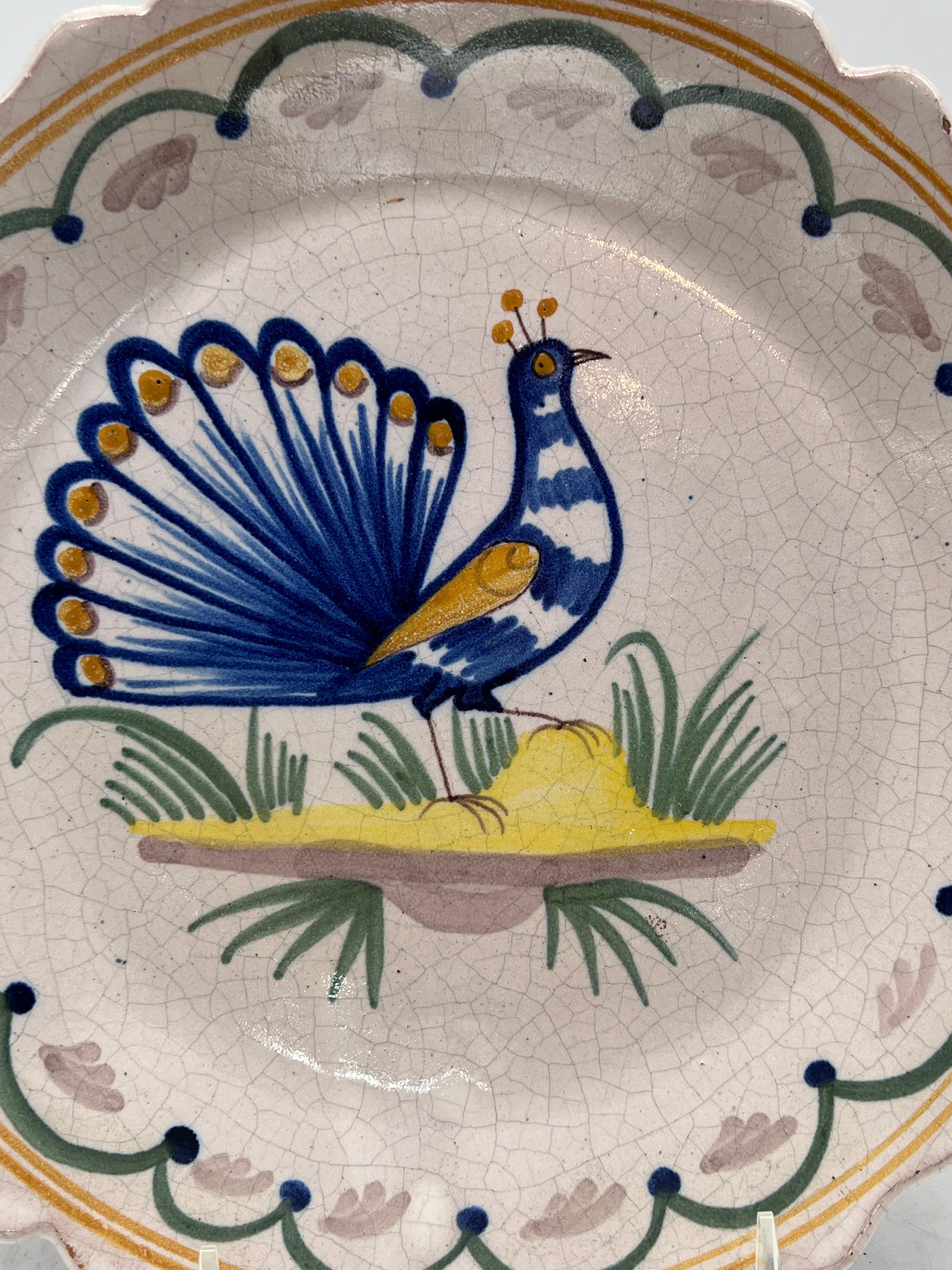 Quimper Pottery, French 20th century.

A vintage Quimper faience pottery plate. The plate has a hand painted and tin glazed peacock to surface and accented by a waved and scalloped edge. 