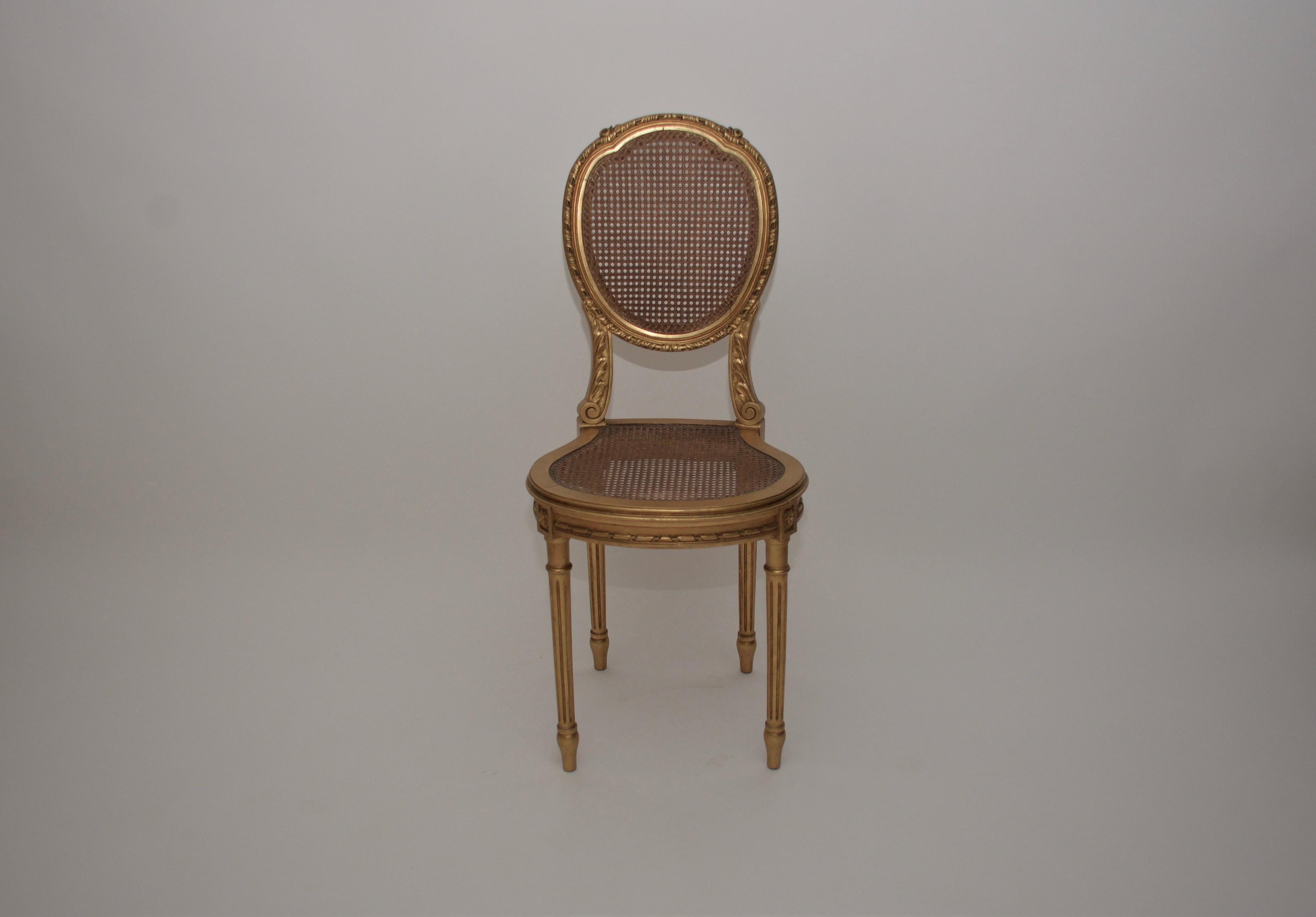 A fabulous French vintage gold gilt rattan chair in the Hollywood Regency style. This chair has lovely intricate detail within the wood work which compliments the rattan seat and back. The seat height is 48cm.