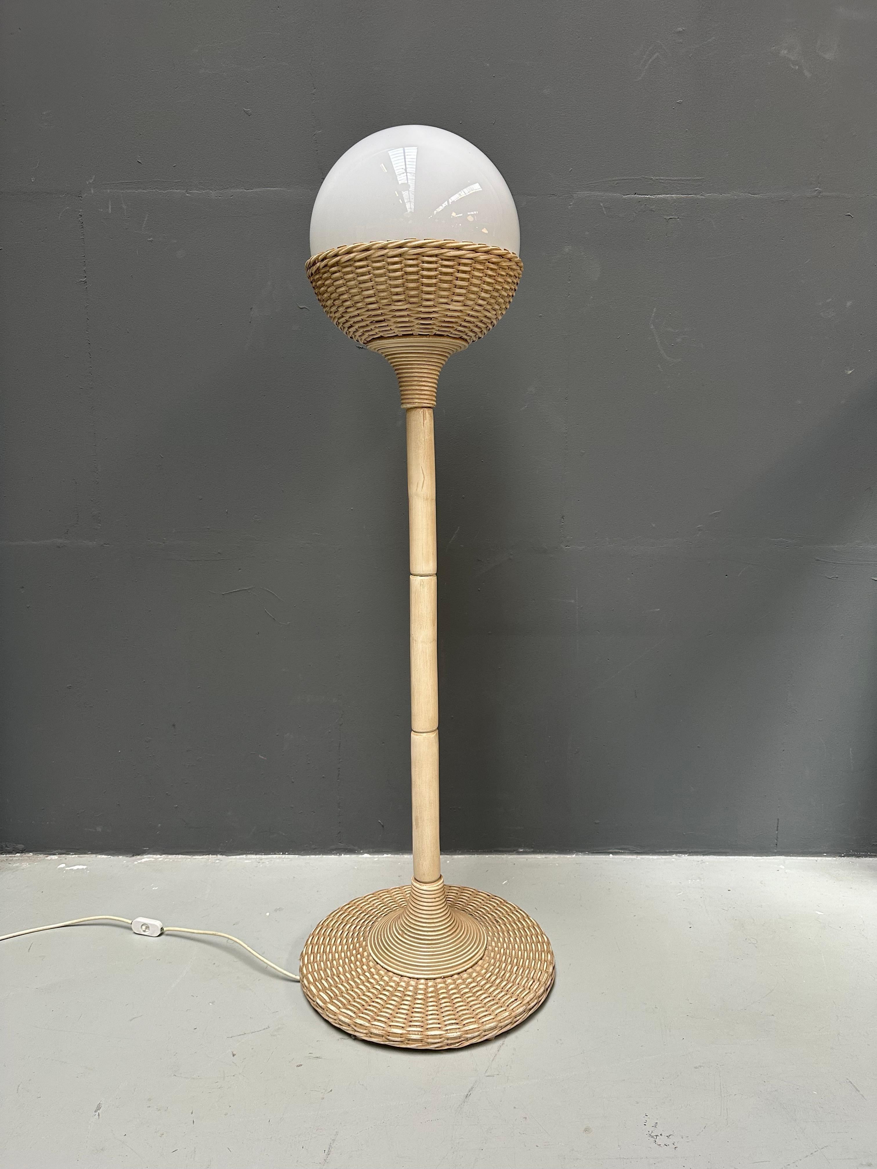 This rattan wicker floorlamp with large glass ball was made in France in the eighties. The condition and wiring has been checked in our workshop and is in very good condition.