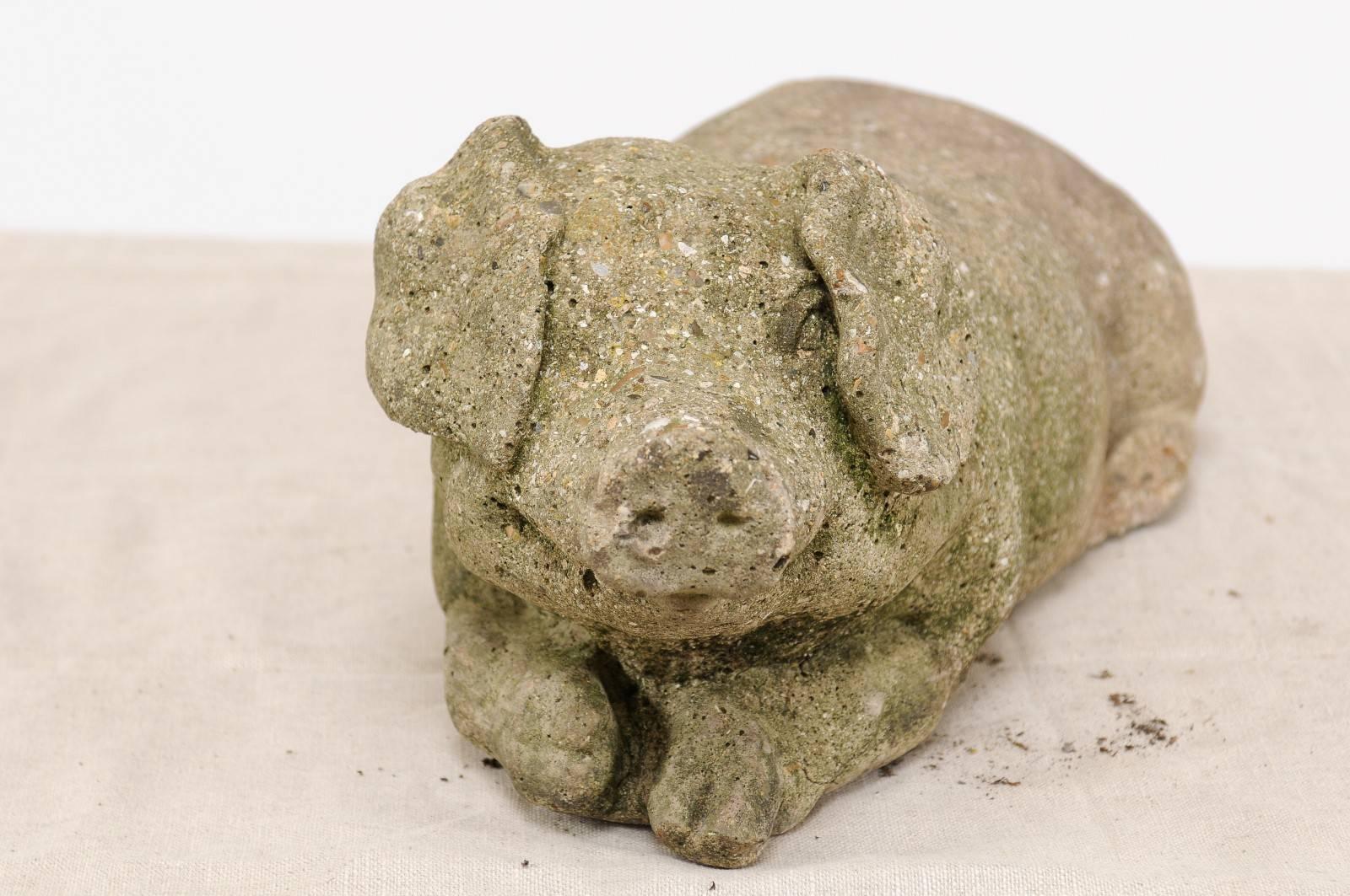 A French reclining stone pig sculpture with nicely weathered patina from the 1920s. We couldn’t resist the sleepy, gentle demeanor of this pretty vintage stone pig that we found lazing happily in a courtyard in the south of France. With his sweet