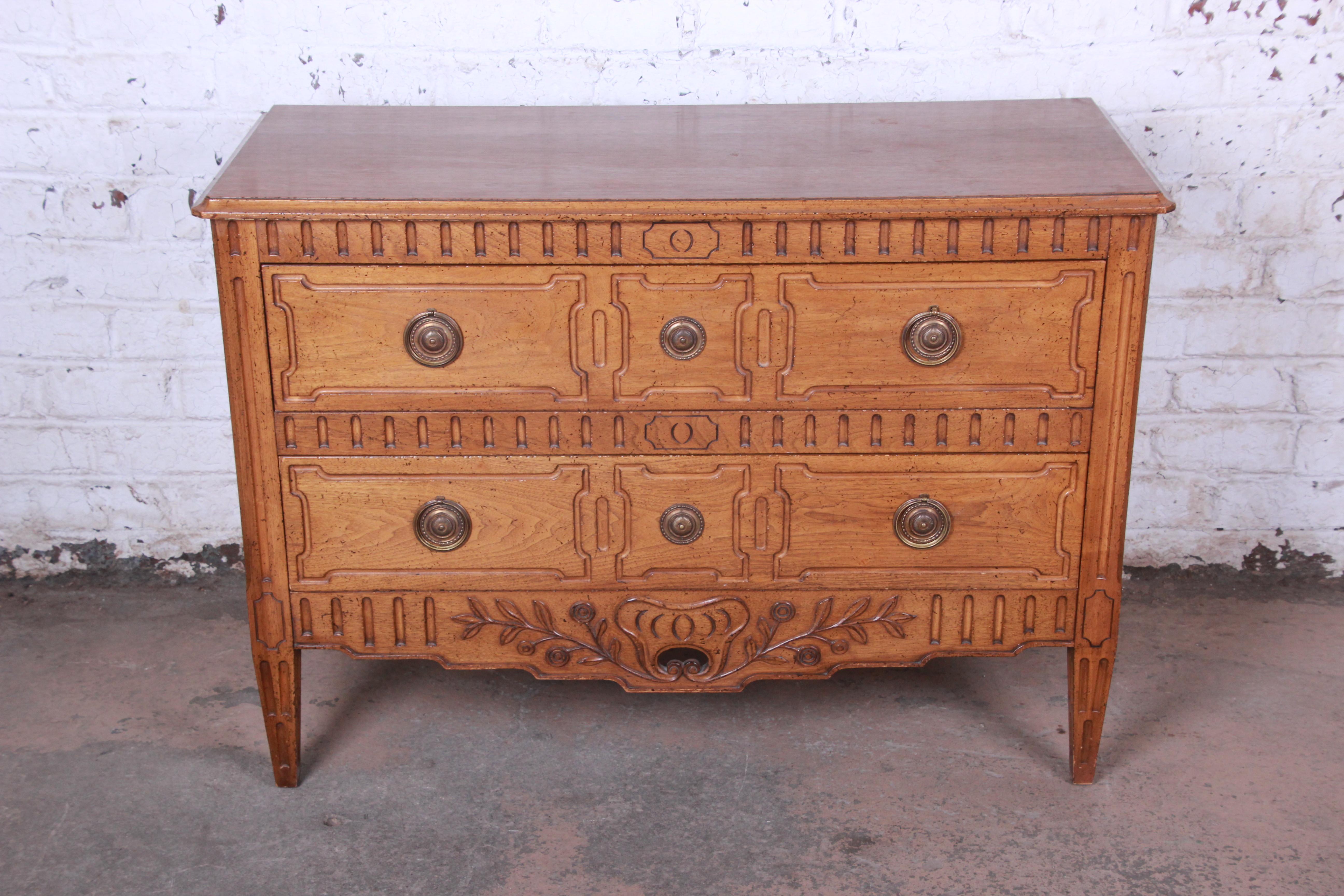 Offering a very nice vintage French Regency dresser by Bodart. The dresser offers two large smooth sliding drawers with original brass ring pulls. It has nice French carved floral details with Regency styled tapered legs. The piece is in very good