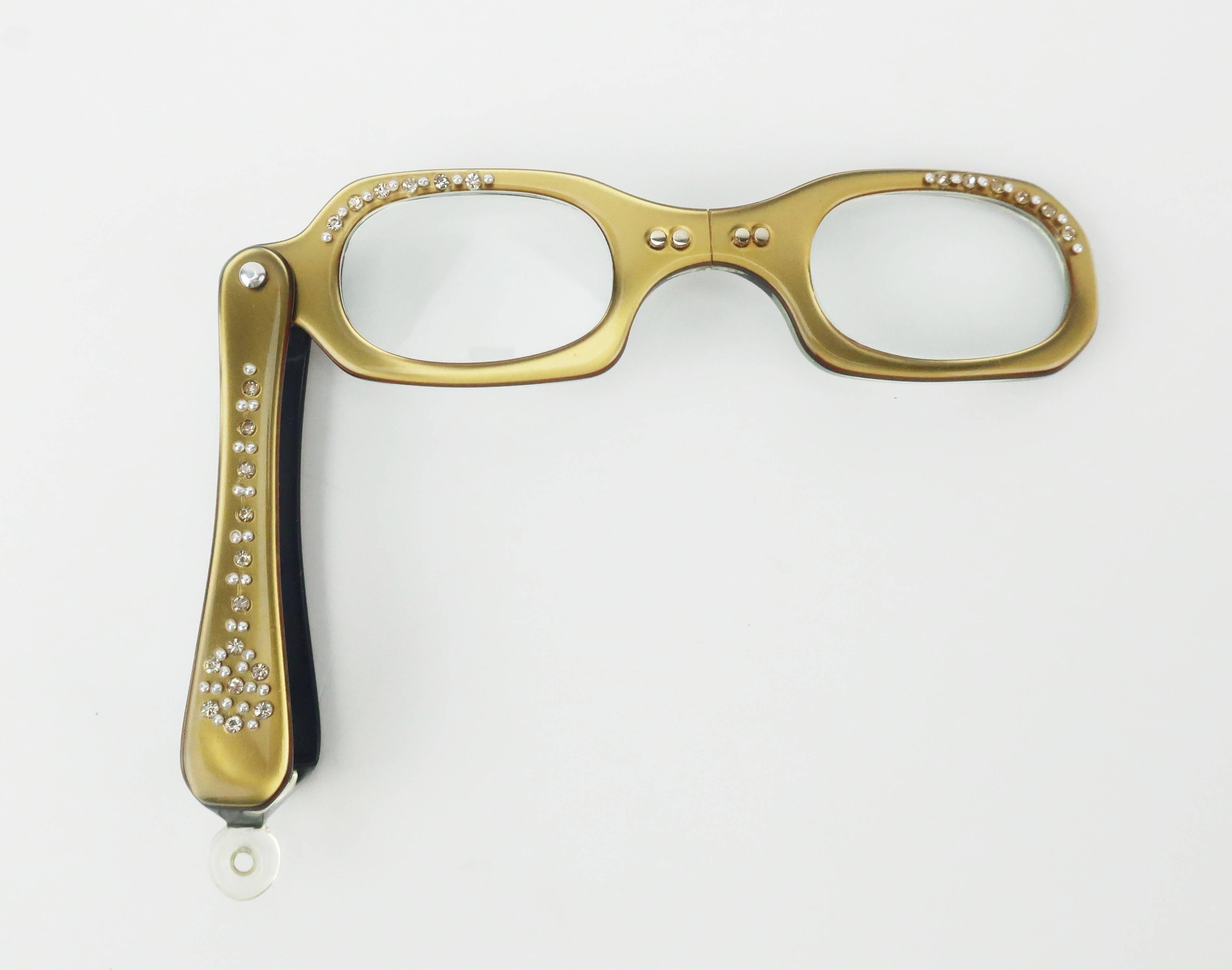 Need a stylish way to read that menu in a dark restaurant?  Here is the perfect solution!  A petite collapsible magnified French lorgnette in a dark golden plastic embellished with sparkling faceted rhinestones and beading.  They come with a brown