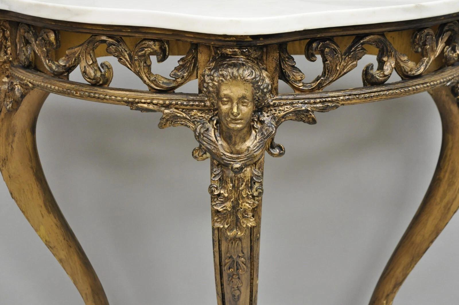 Vintage French Rococo Style Dark Distressed Gold Gilt Gesso Marble Top Console Table with Maiden Faces. Circa Mid 20th Century. Measurements: 32