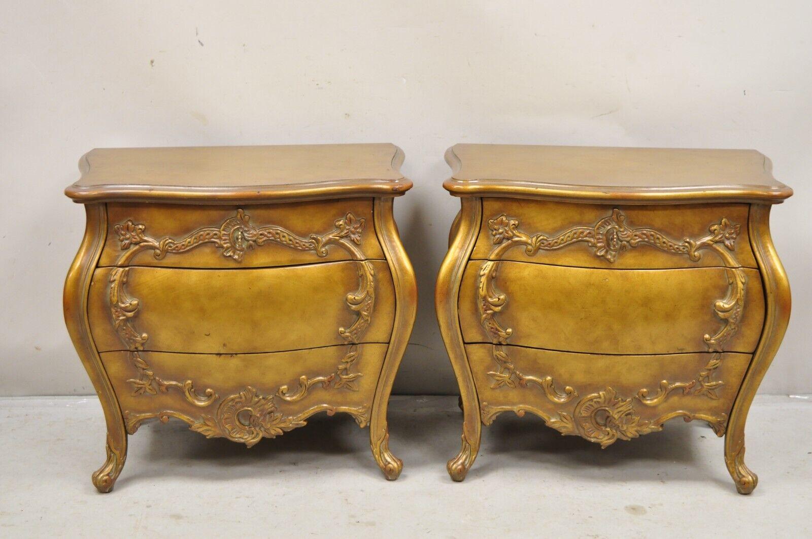 Vintage French Rococo Baroque Style Gold Gilt Bombe Nightstands -  a Pair. Item features heavy solid wood construction, distressed gold gilt finish, shapely bombe form, 3 dovetailed drawers, quality American craftsmanship. Circa Mid 20th Century.
