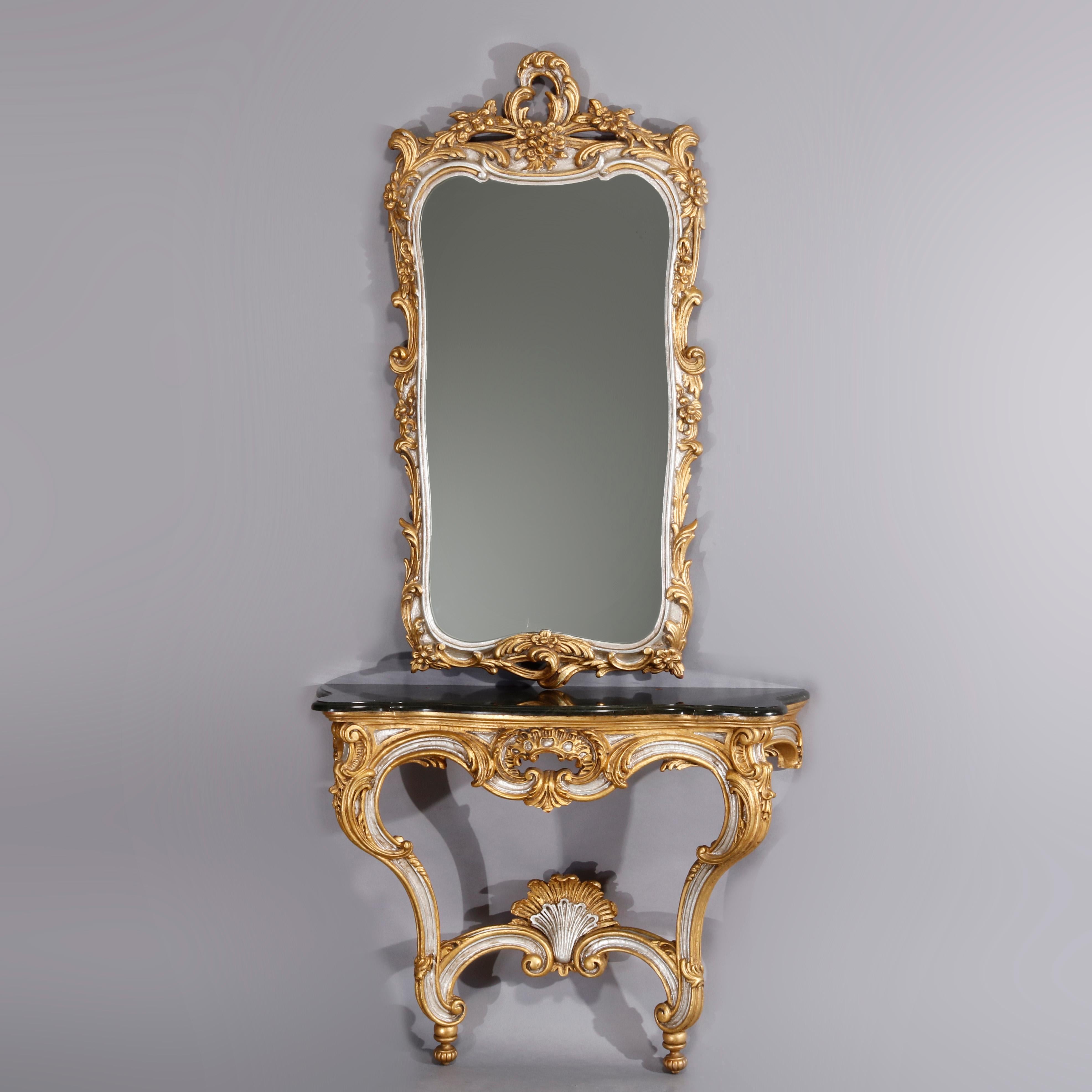 A vintage French Rococo style console by VDA De Hurtado, S. A. offers silver and gold giltwood pierced frame having scroll and foliate cartouche surmounting mirror with scroll and foliate form frame; table with shaped marble top over scroll and