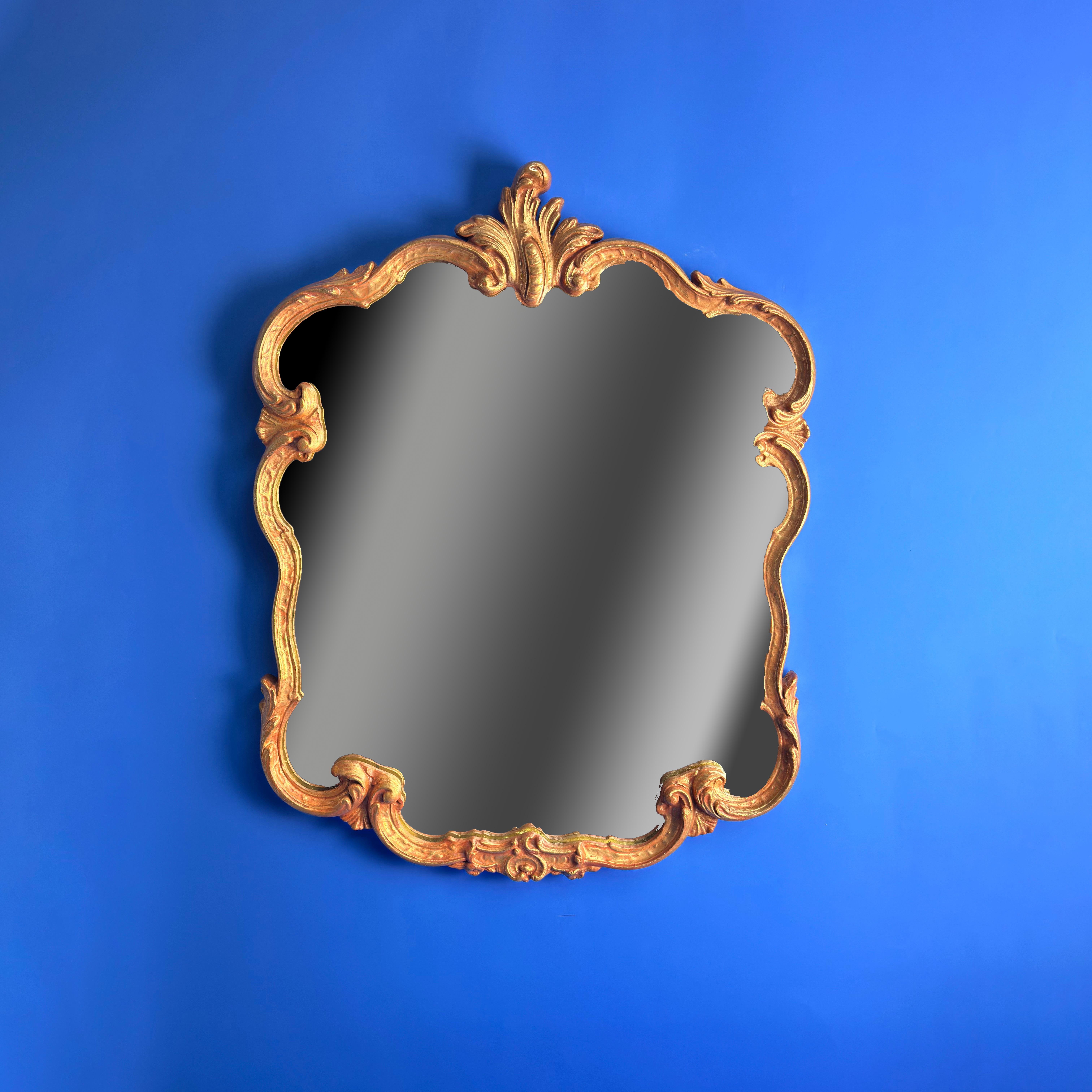  Miroir mural doré de style rococo français des années 1960 

Ce miroir mural de style rococo des années 1960 affiche une élégance simplifiée avec son mince cadre en plâtre gesso orné de feuilles d'acanthe et de détails de coquillages, fini en