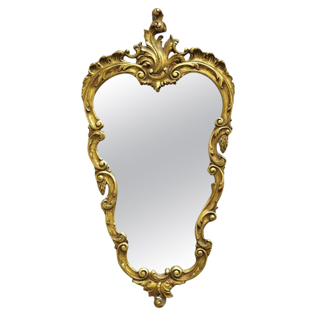 Vieux miroir mural de style rococo français en cuir doré et à volutes