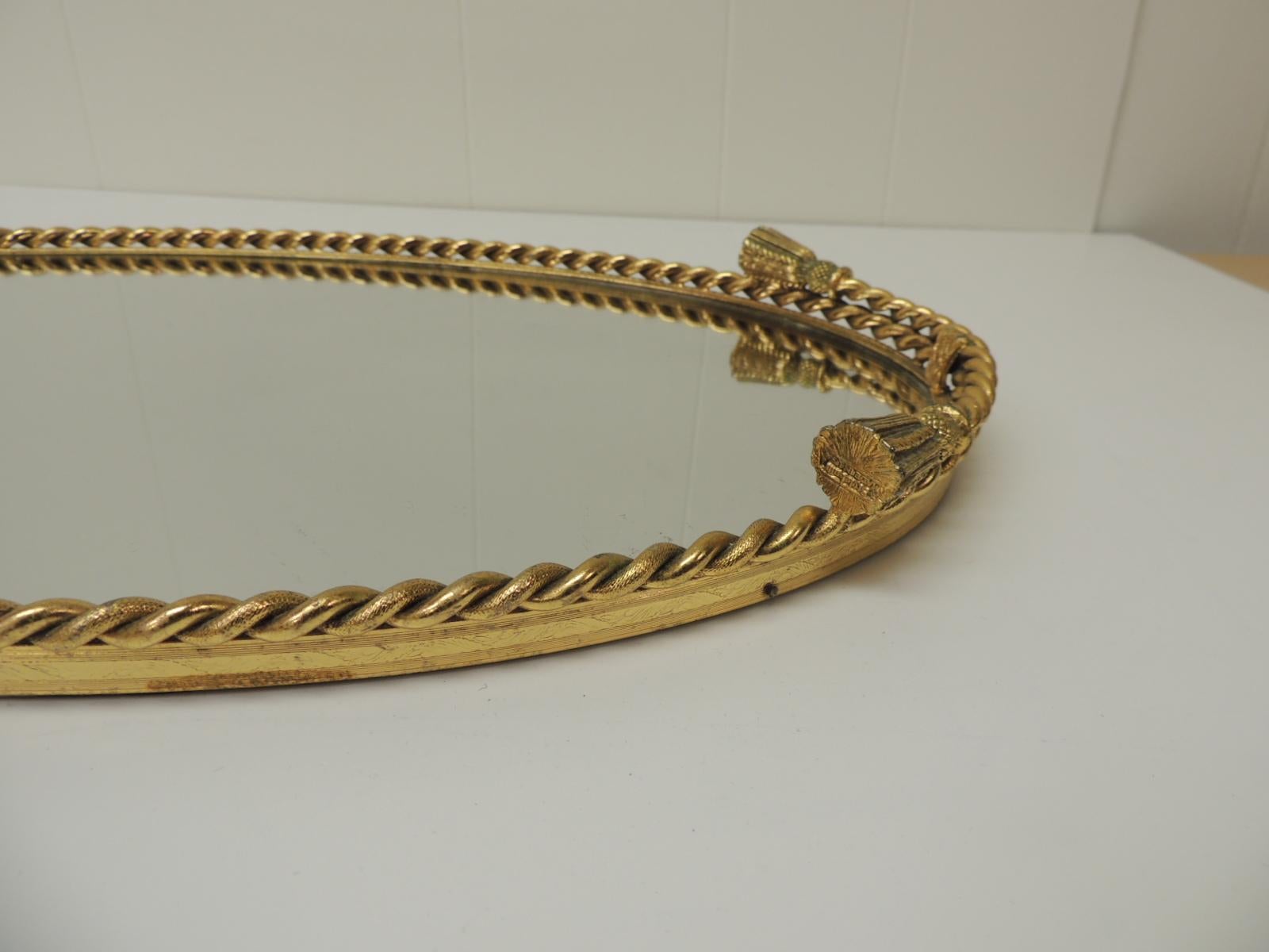 Vintage French rope and tassels large oval brass vanity tray with mirror
Rope and tassels all around the tray edge with oval mirror inset. Felt backing.
French, 1950s.
Size: 18.5 x 11 x 1.5.
 
