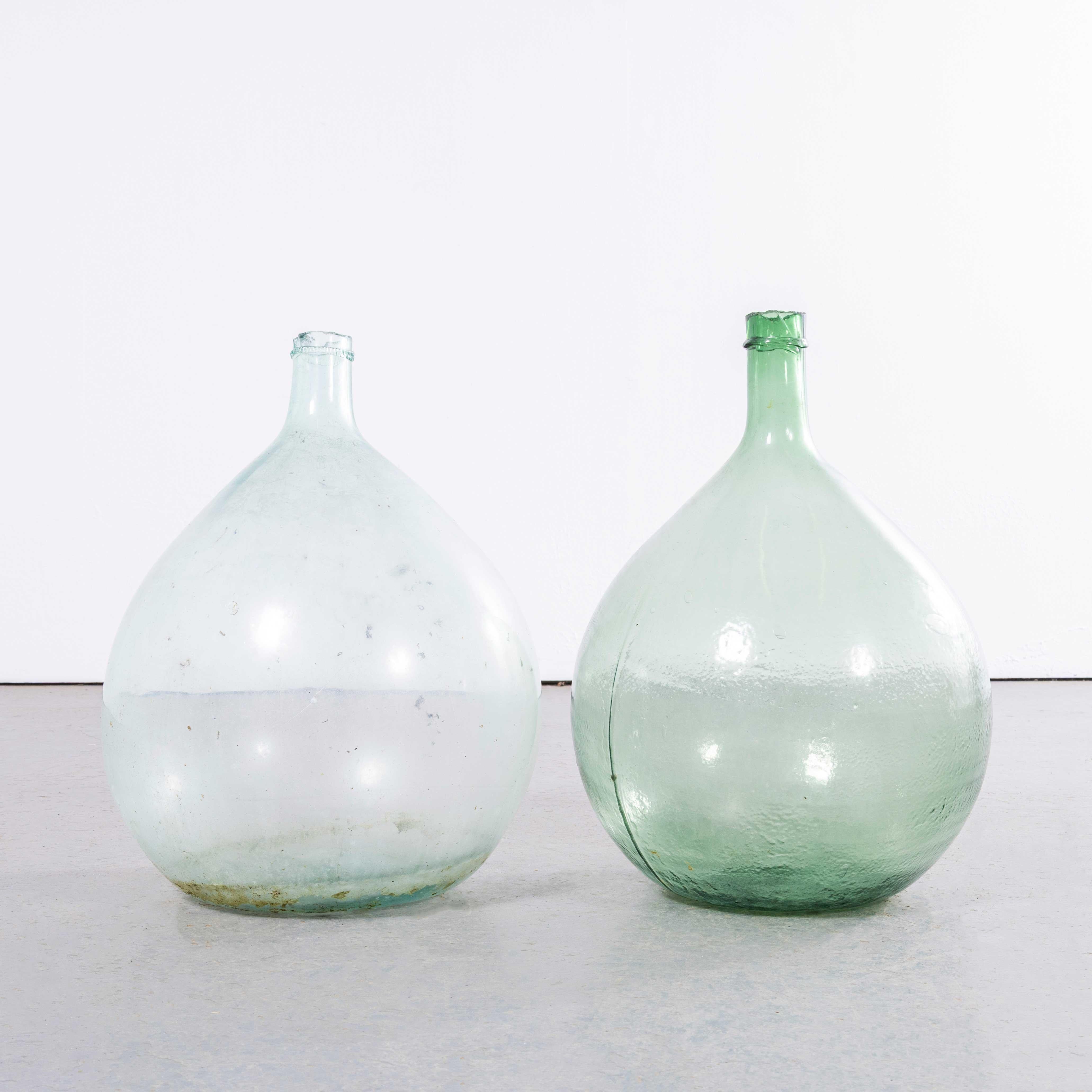 Damigiane rotonde francesi d'epoca in vetro blu e verde - Coppia. 

Una coppia di damigiane in vetro soffiato a bocca utilizzate come contenitori tradizionali principalmente per la conservazione e il trasporto del vino. Queste damigiane sono state