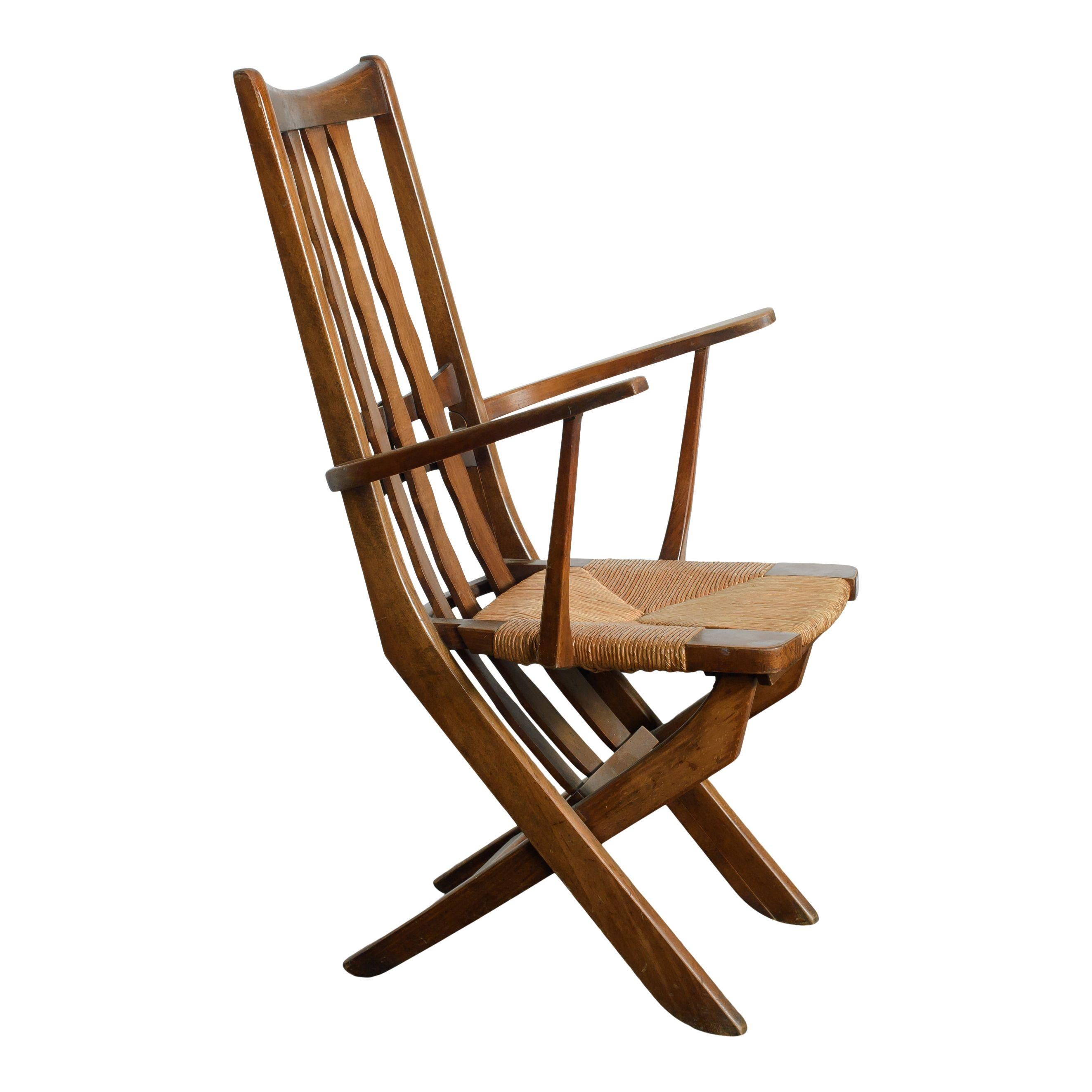 A pristine mid-century modern wood armchair with a rush seat. The carved details of the wood back slats and the smooth sealed wood give this piece such a clean and organic feel. The rush seat is another organic touch and is in perfect condition. The