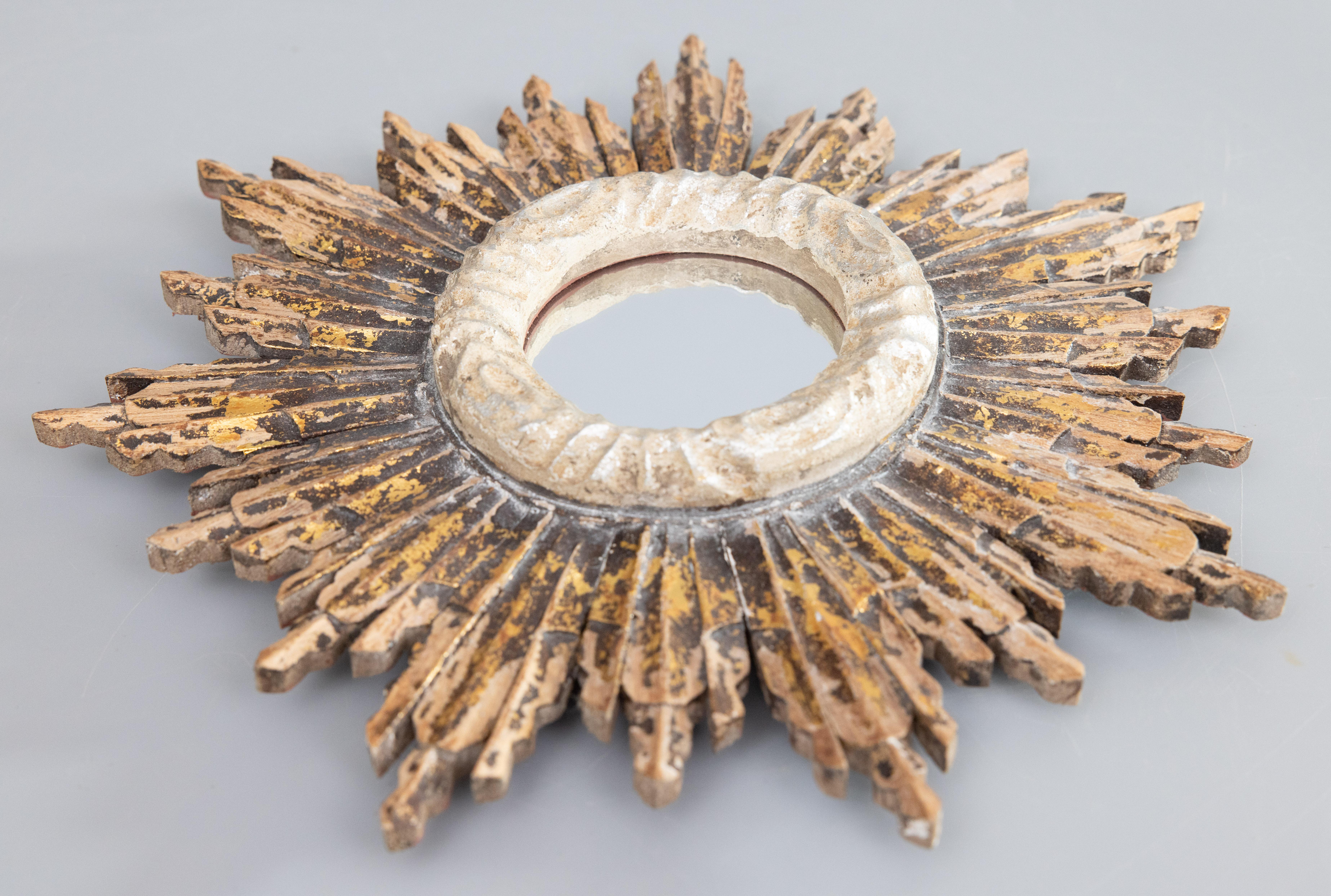 Uno splendido specchio d'epoca francese in legno dorato a raggiera. Questo elegante specchio è circondato da una cornice decorativa argentata e da deliziosi raggi intagliati di lunghezza alternata con una bella patina dorata rustica e distorta. Se
