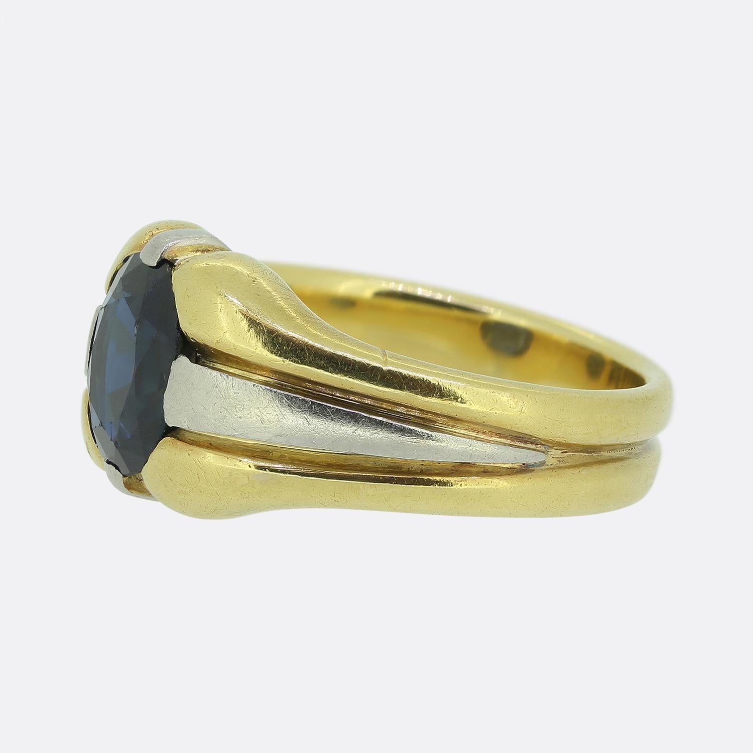 Ecco un favoloso anello Single Stone con al centro un affascinante zaffiro blu intenso. Questo zaffiro dal taglio ovale è incastonato in un design robusto, che combina il calore dell'oro giallo 18ct con l'eleganza degli accenti in platino. La fascia