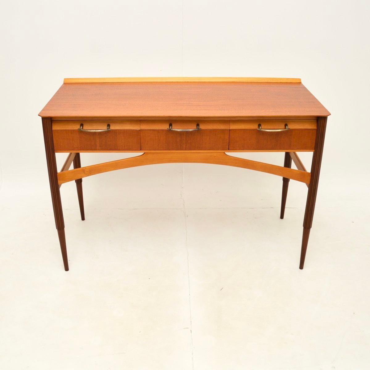 Un élégant et très stylé bureau / table console en bois satiné français, datant des années 1950.

Ce produit est magnifiquement conçu et d'une qualité irréprochable. Sa taille est idéale pour servir de bureau, de console ou de coiffeuse. Le bois
