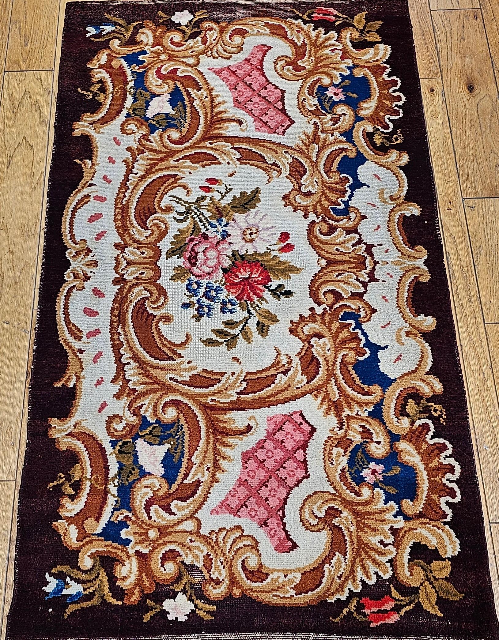 Vintage French Savonnerie hand-knotted area rug circa the early 1900s.  The Savonnerie rug has a classic floral pattern set on a rich chocolate brown background with wonderful design colors in red, pink, blue, and ivory.  This rug (SKU 1736) and the