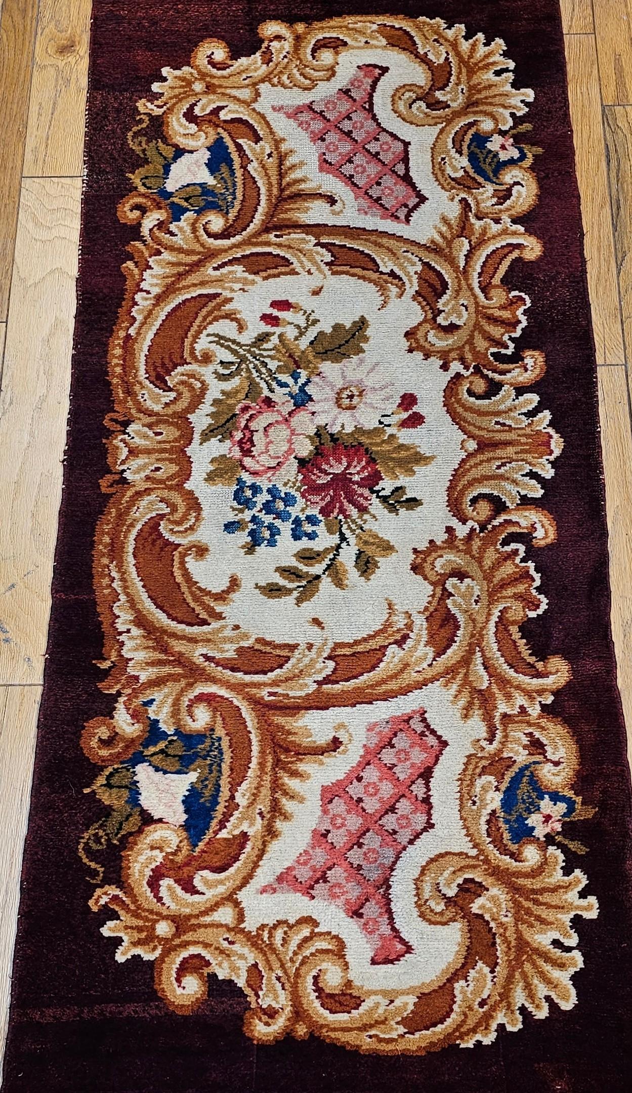 Vintage French Savonnerie hand-knotted area rug circa the early 1900s.  The Savonnerie rug has a classic floral pattern set on a rich chocolate brown background with wonderful design colors in red, pink, blue, and ivory.  This rug (SKU 1737) and the