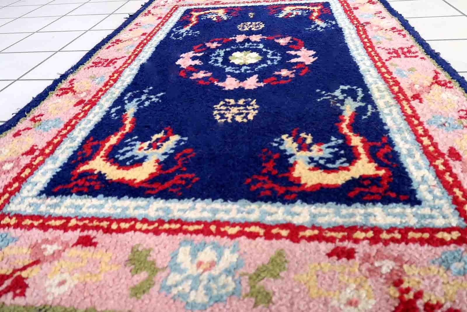Vintage French Savonnerie rug in night blue and pink colors. The rug has been made in wool in the end of 20th century. It is in original good condition. The rug has dragon design.

-condition: original good,

-circa: 1960s,

-size: 2.9' x 4.5'