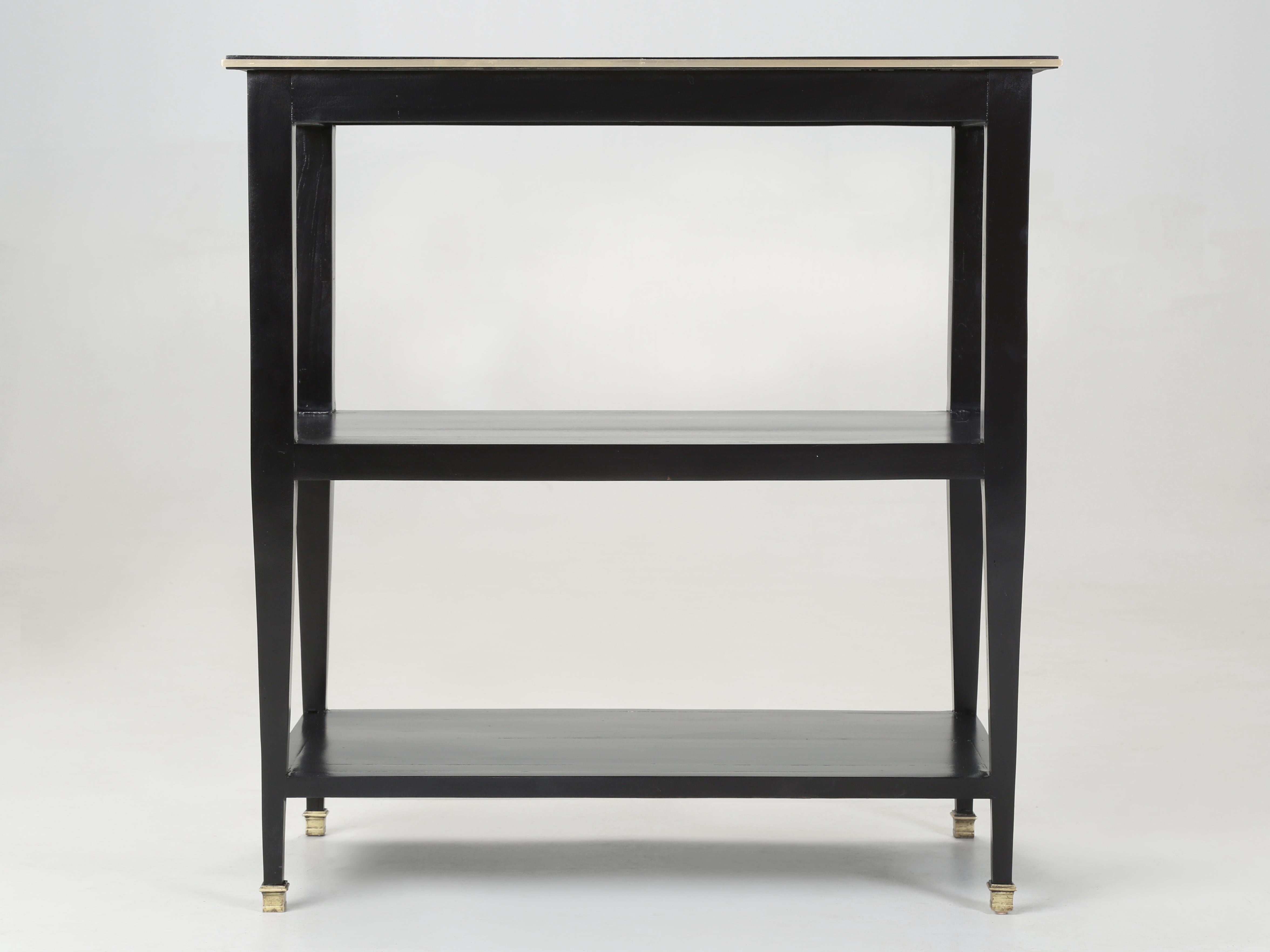 Vintage French Side Table or End Table restored with an Ebonized stain finish. The top is trimmed with a solid brass molding and the sabots are also solid brass. Constructed from hard wood which our finishing department stripped to the bare wood,