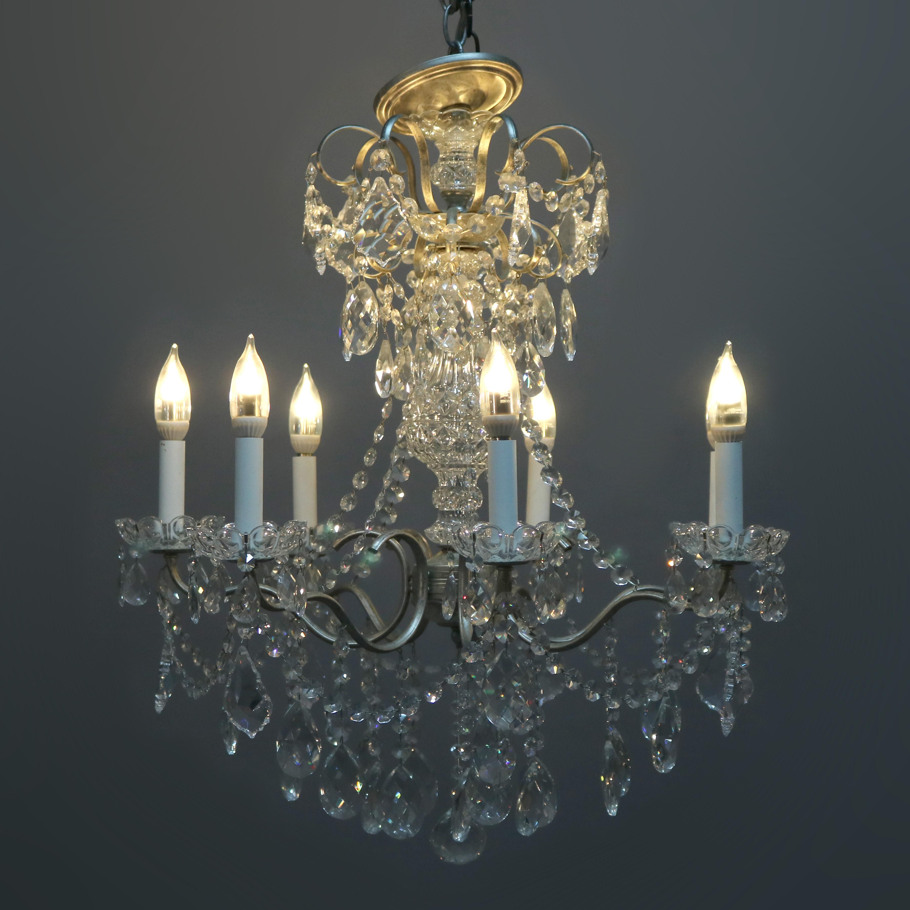 A vintage French chandelier offers silver gilt frame with scroll form arms terminating in candle lights with strung and drop cut crystals throughout, 20th century

Measures: 33.5