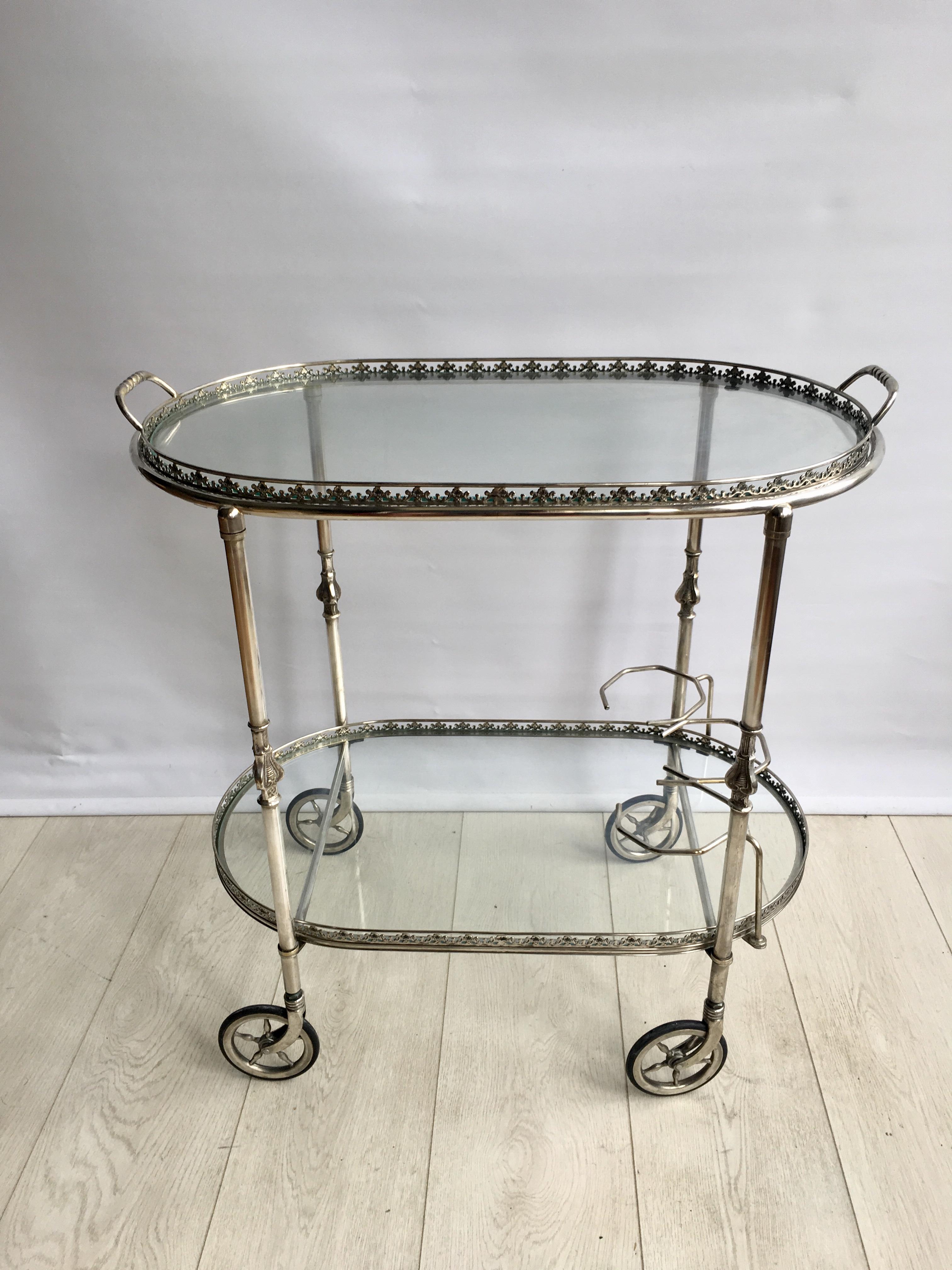 Vintage oval drinks trolley from France, circa 1950

Polished silver frame with decorative fretwork and a lift off top tray 

Top tray measures 63 cm wide (67 cm with handles), 37 cm deep and stands 64 cm to glass

Overall dims 67 cm wide,