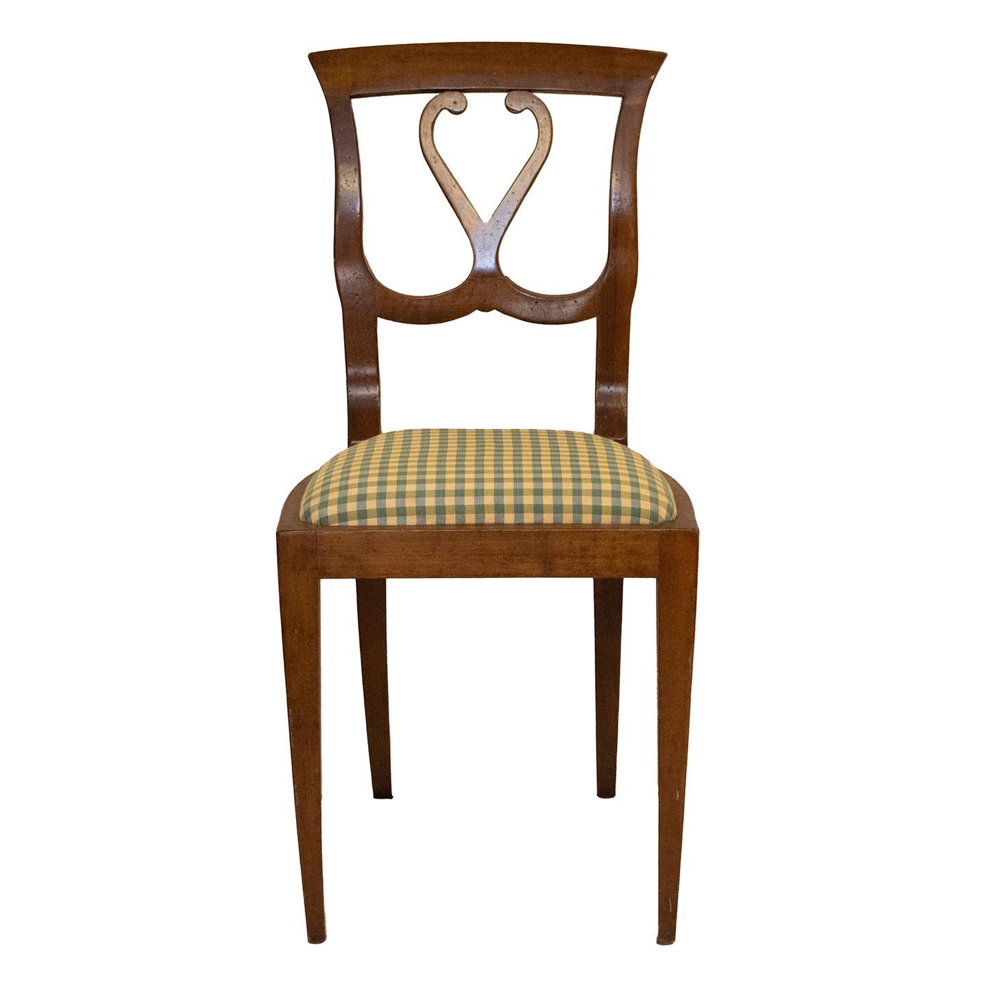 An elegant French provincial single chair that is delicate in its proportions. The chair features an open back with scrollwork and gentle curves.T he seat is upholstered in a silk check. The chair has a gorgeous patina and has aged well like a fine
