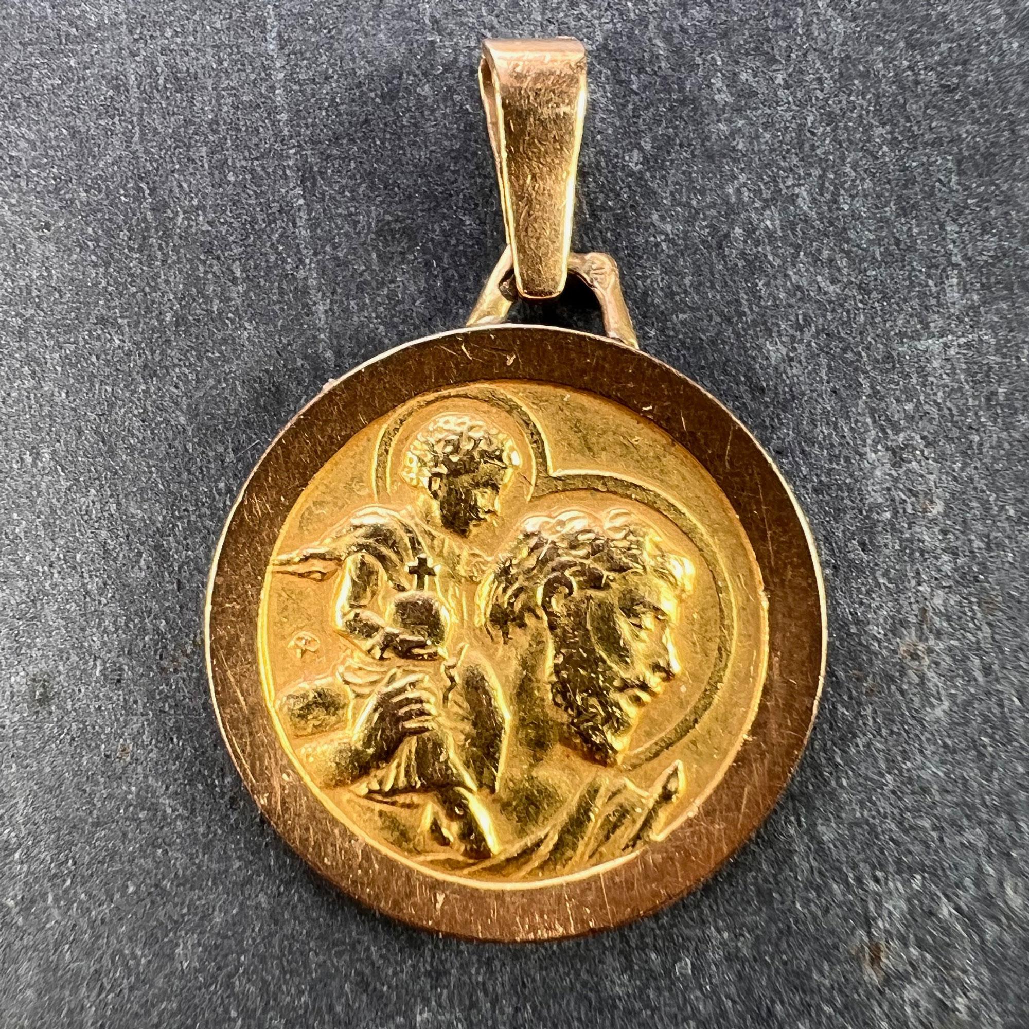 A French 18 karat (18K) yellow and rose gold charm pendant depicting the head of St Christopher as he carries the infant Christ across a river. Stamped with the eagle’s head for French manufacture and 18 carat gold, and an unknown maker’s mark. The