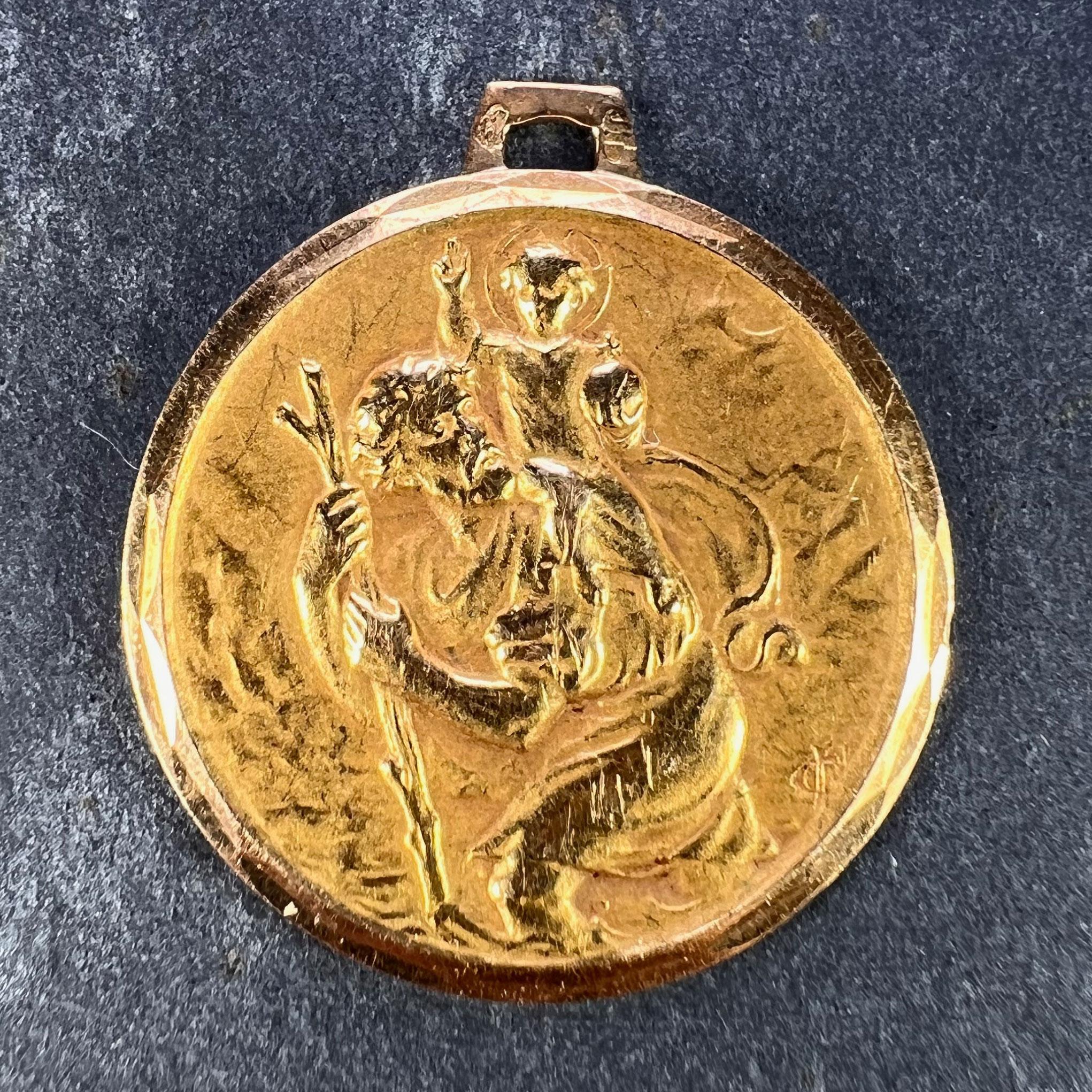 A French 18 karat (18K) yellow gold charm pendant designed as a medal depicting St Christopher as he carries the infant Christ across a river with an unknown signature. Stamped with the eagle’s head for French manufacture and 18 karat gold, and an