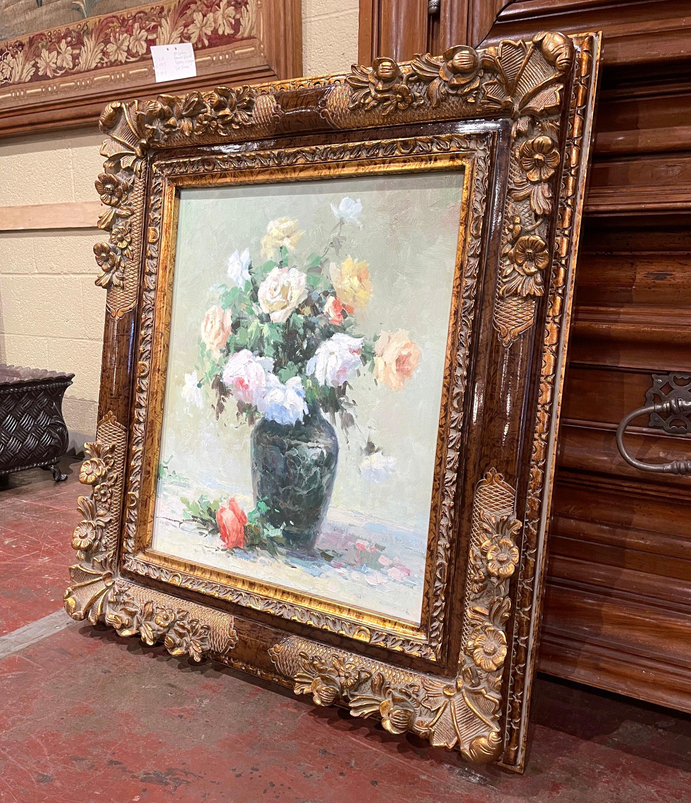 Hand painted in France circa 1980 and set in the original carved giltwood frame, the colorful art work on canvas depicts a still life scene with a terracotta cachepot filled with roses and foliage in the manner of Marcel Dyf. The painting is in