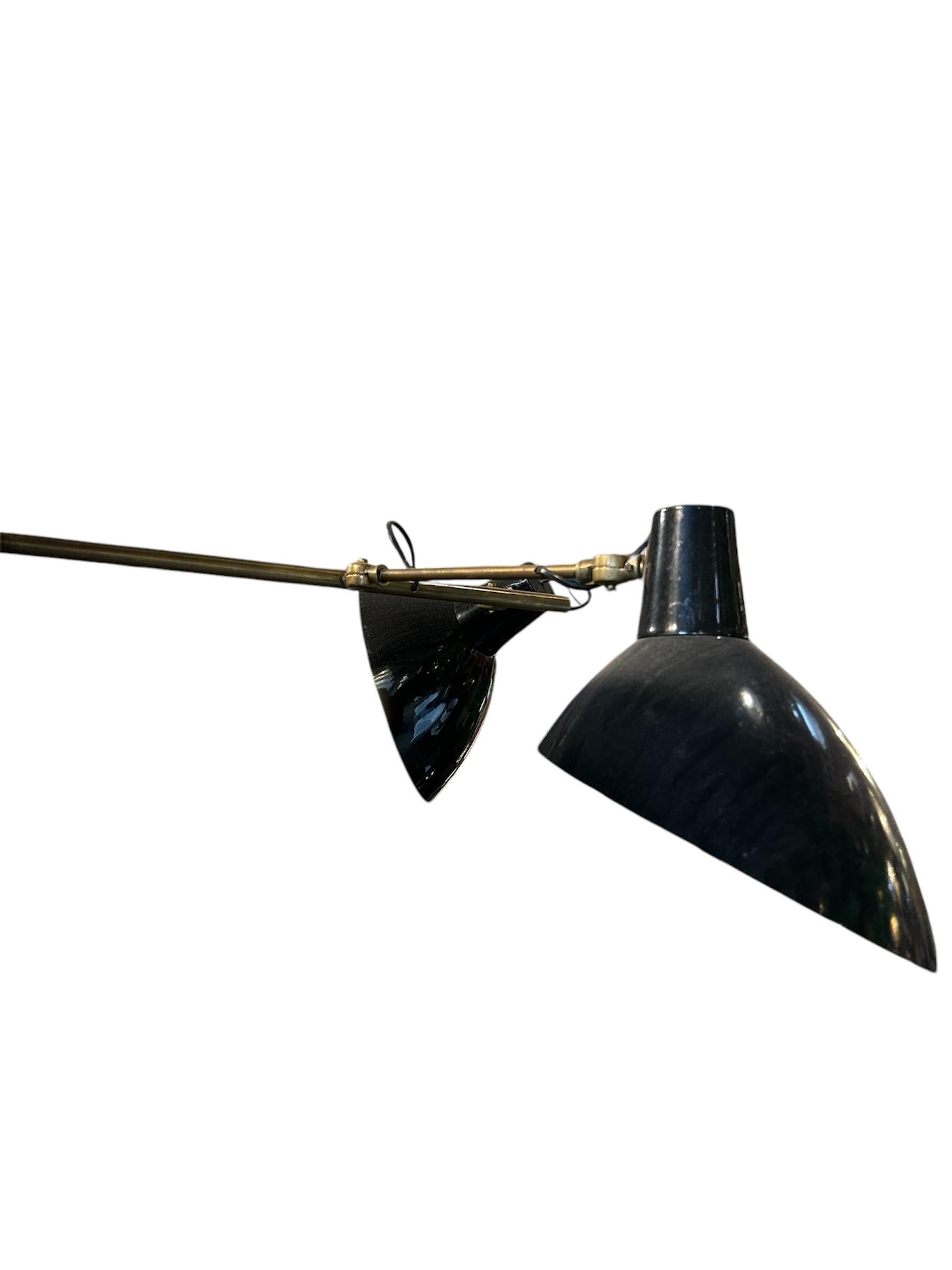 This French style brass pendant light combines vintage industrial style with modern versatility. Its adjustable dual-arm design, sleek brass hardware, and black metal shades create a striking contrast, while pivoting joints offer customizable