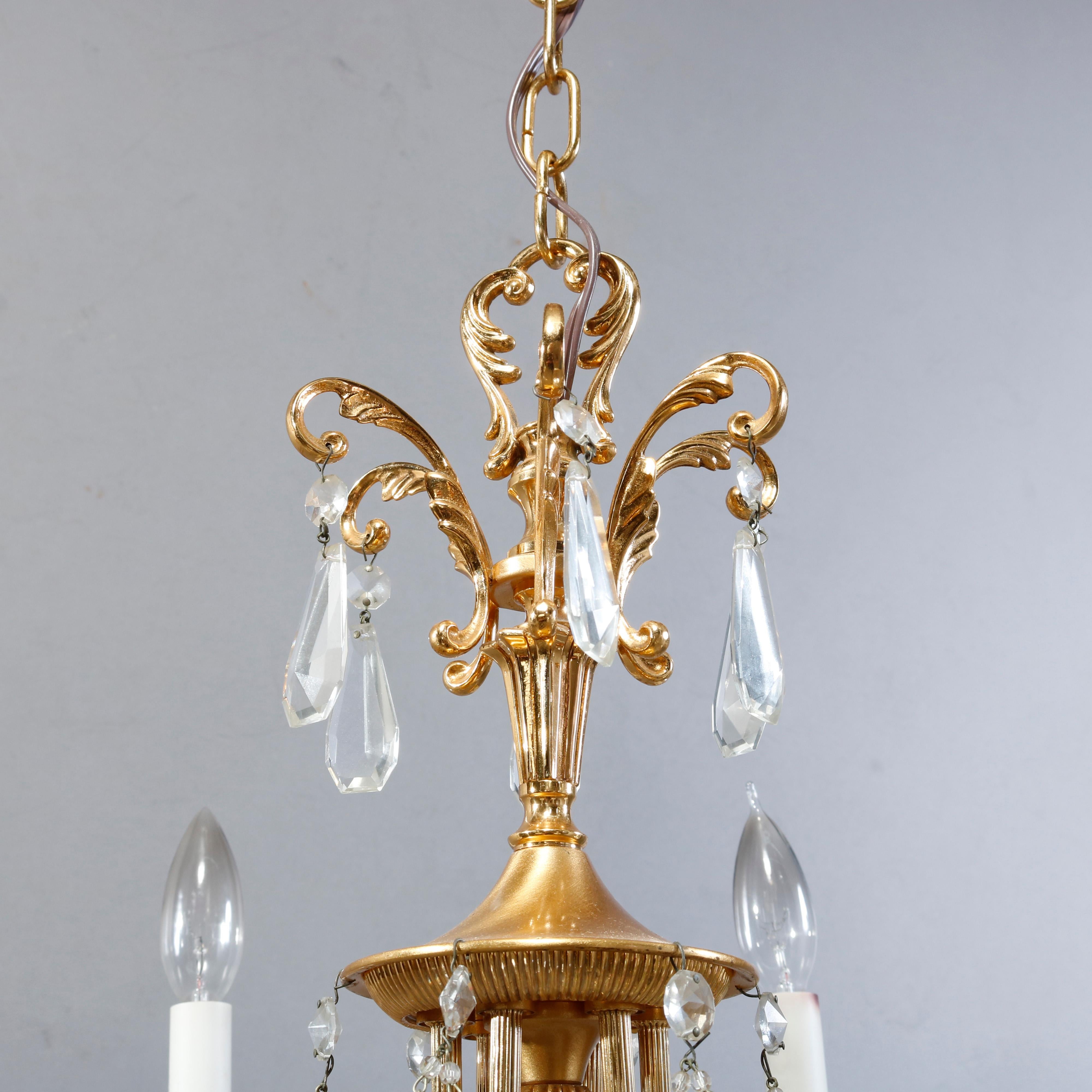 A vintage French style chandelier offers brass frame with six c-scroll reeded arms terminating in urn form sockets with flanking foliate elements and candle lights, strung cut crystals throughout, c1940

Measures: 19.5