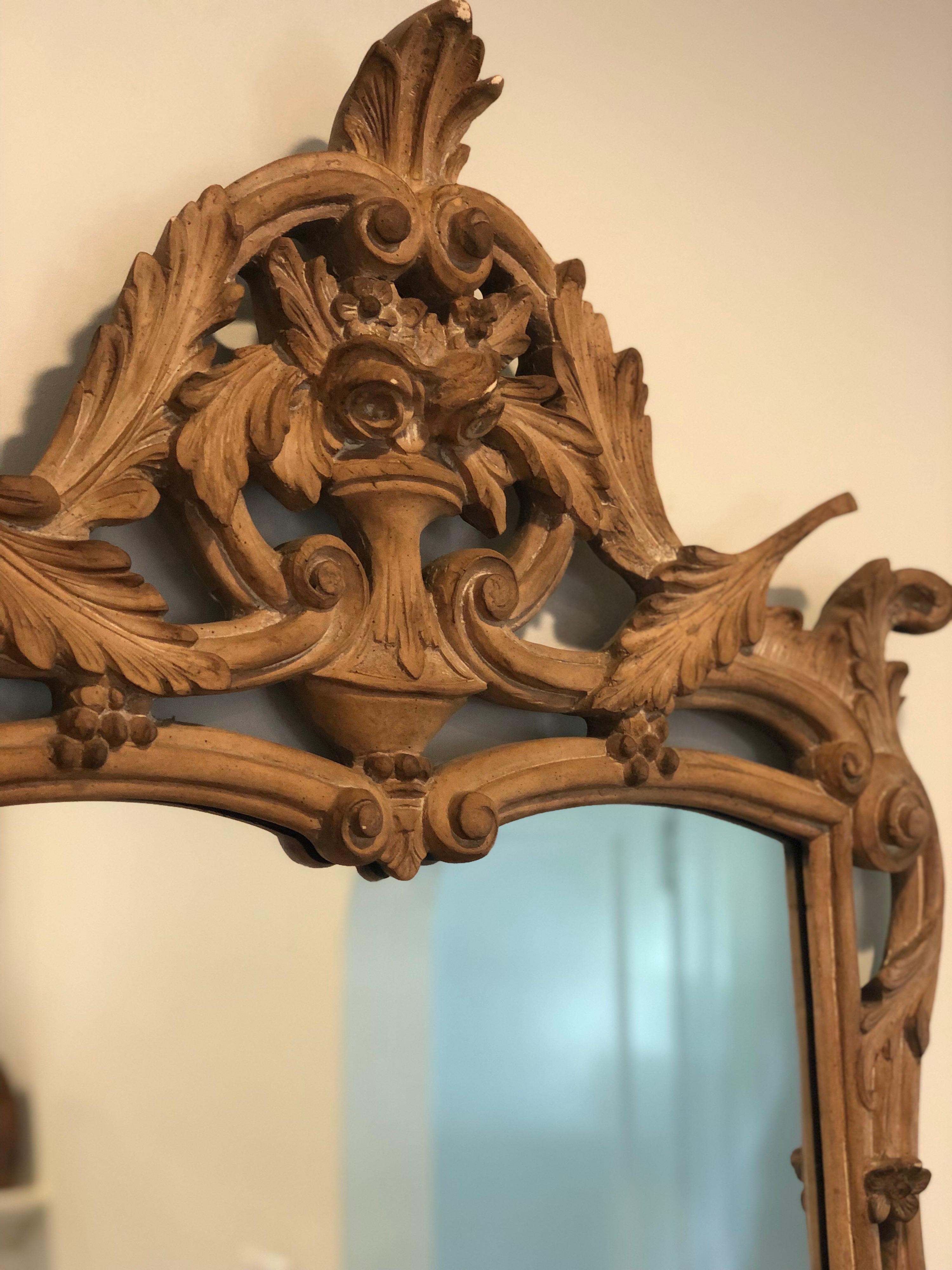 Vintage French style mirror made by Mirror Fair. 
Hand carved with. leaves and flowers in an urn. 

Raw unfinished wood with natural patina gives it a contemporary flare.