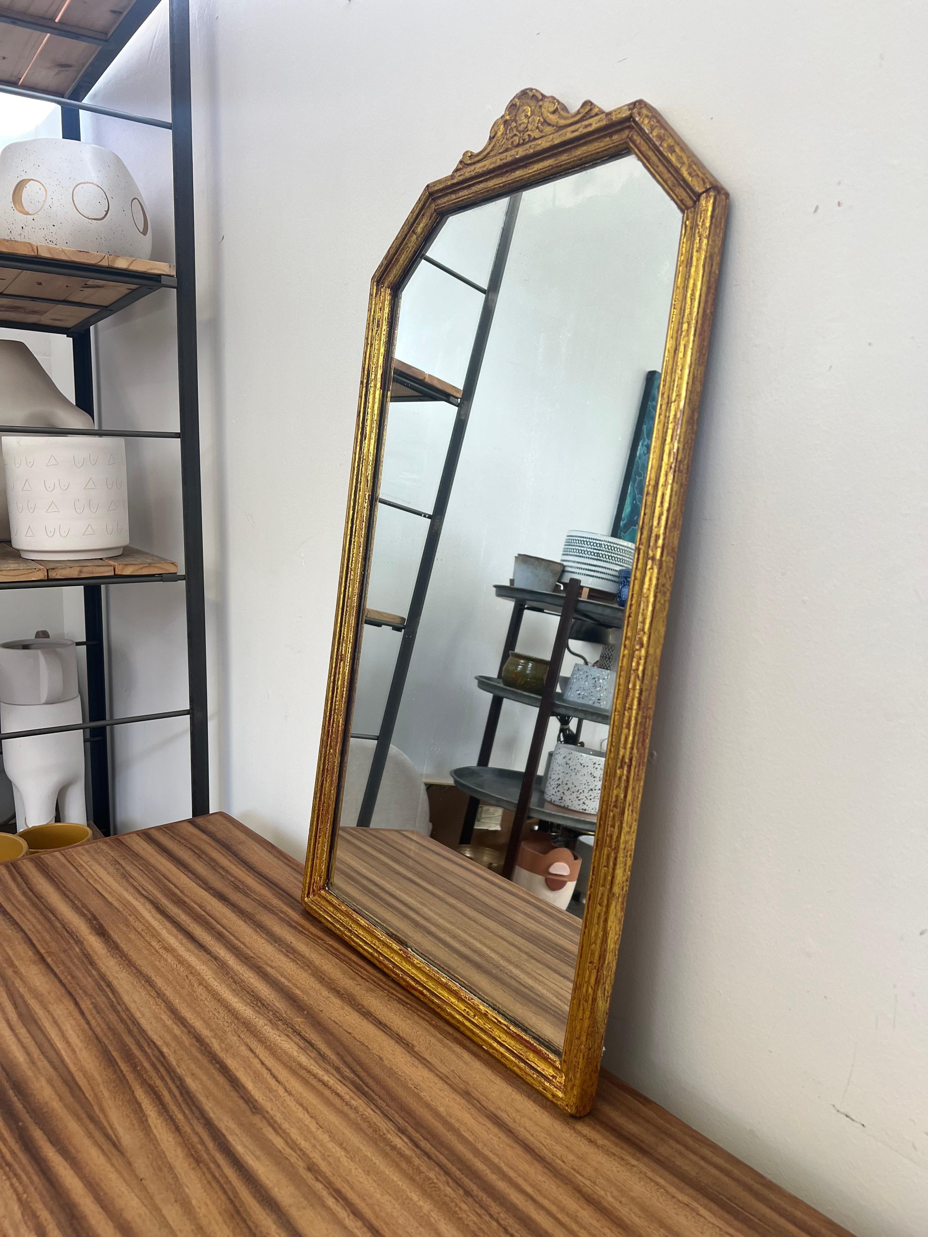  Vintage-Spiegel in Goldton mit Blumenmotiv oben. Nach der Rückseite zu urteilen, könnte es aus Holz sein, was wir nicht überprüfen können. Vintage Condition Konsistent mit dem Alter wie abgebildet.

Abmessungen. 16 B; 3/4 T; 29 1/2 H