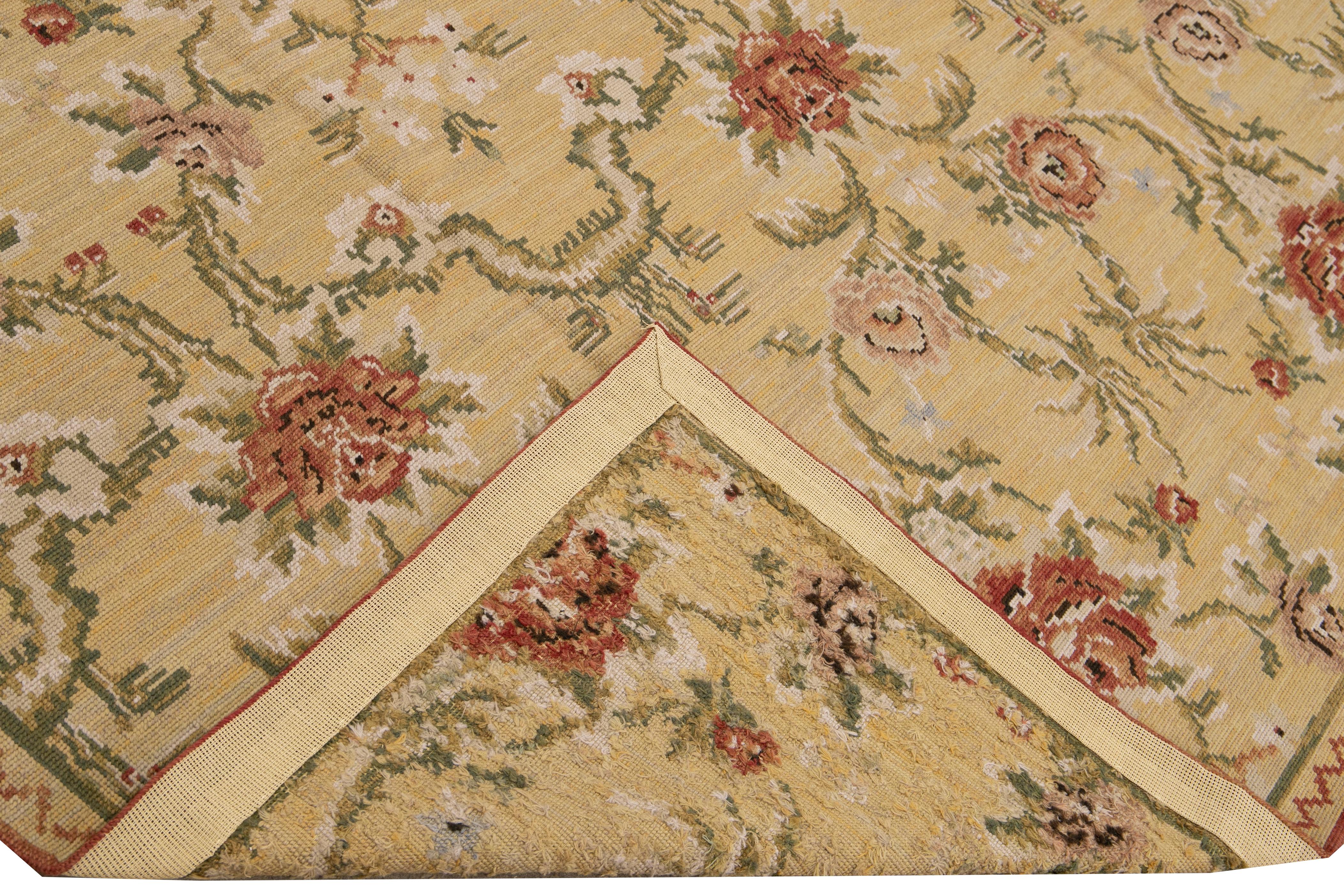 Magnifique tapis en laine aiguilleté de style français vintage avec un champ beige. Cette pièce a des accents verts, roses, roses et ivoires dans un magnifique motif floral. 

Ce tapis mesure 7'10