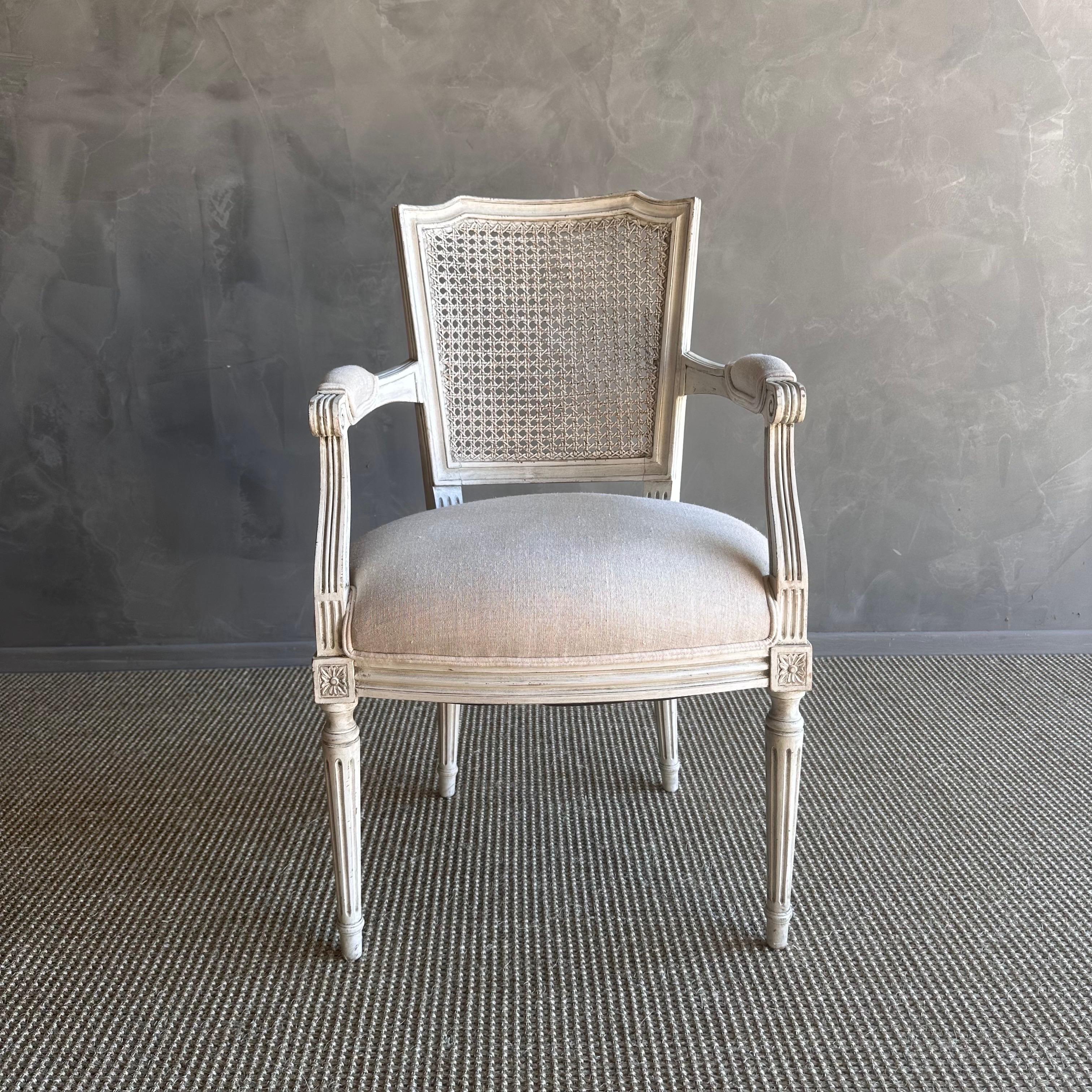 Vintage French Style chairs upholstered in luxurious linen fabric. This vintage French accent chair is crafted with intricate details and a cane back, adding a touch of elegance to any space. Whether placed in a cozy reading nook or as a statement