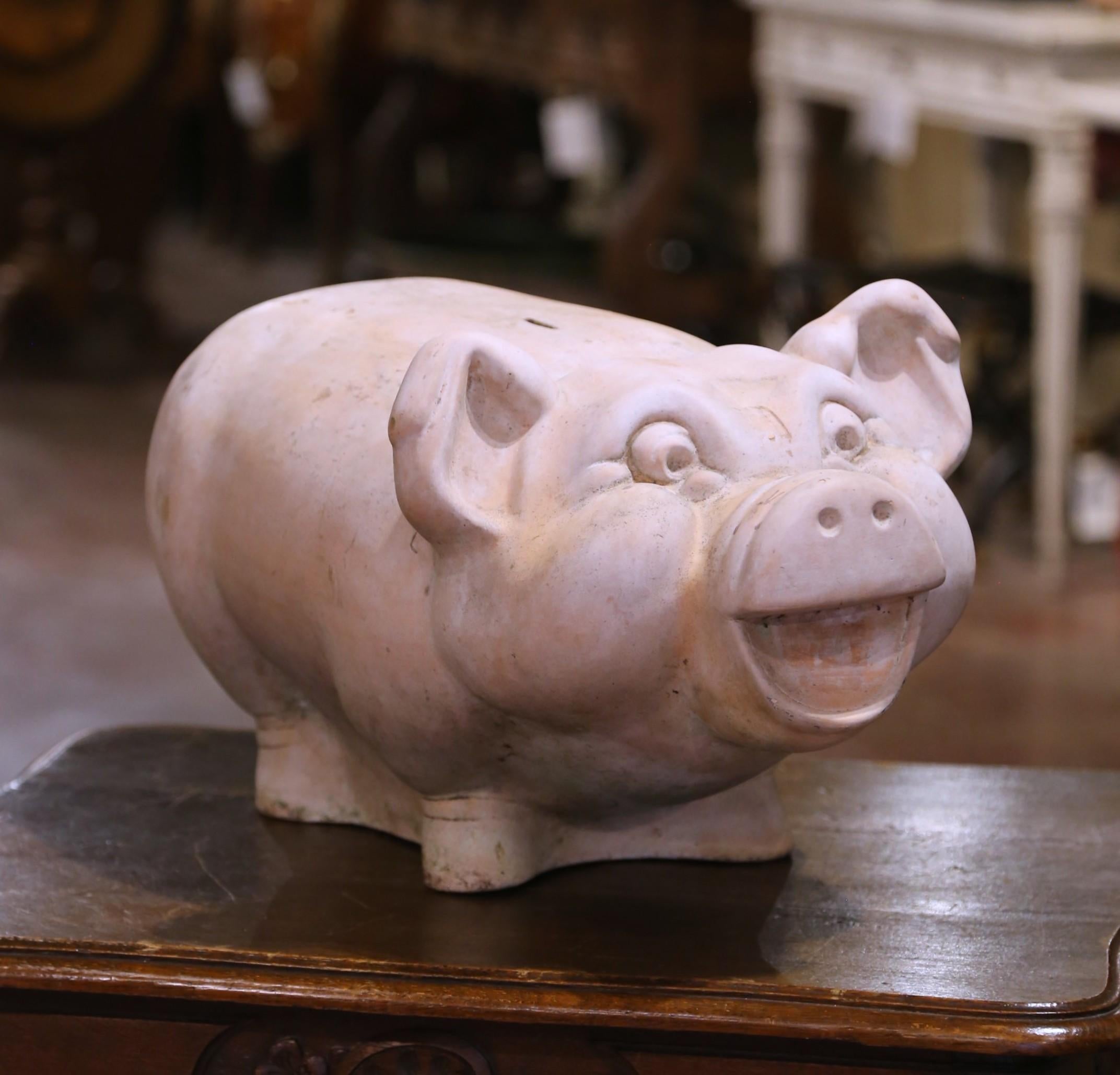 Aggiungi fascino e carattere al tuo giardino, al tuo patio o al tuo interno con questo salvadanaio in terracotta sovradimensionato, scolpito a forma di gioioso maiale dai tratti esagerati e dal sorriso allegro. Realizzato nel 1970 circa, il pezzo