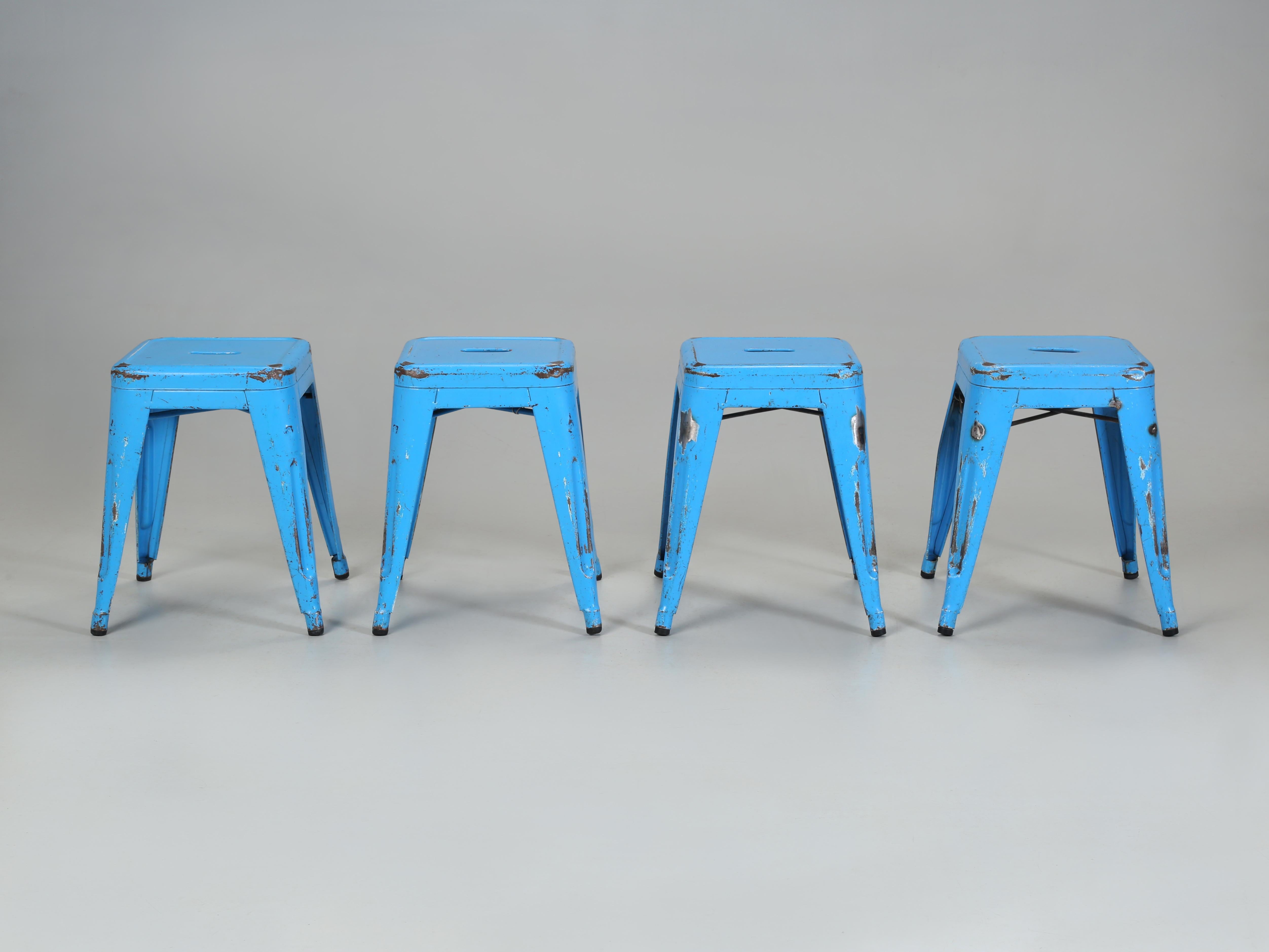 Vintage French Tolix Dining Table height Steel Stacking Stools that were hand-made in France. The distressed original paint is still serviceable and they can certainly be repainted in the future. We currently stock over 1000 pieces of genuine French