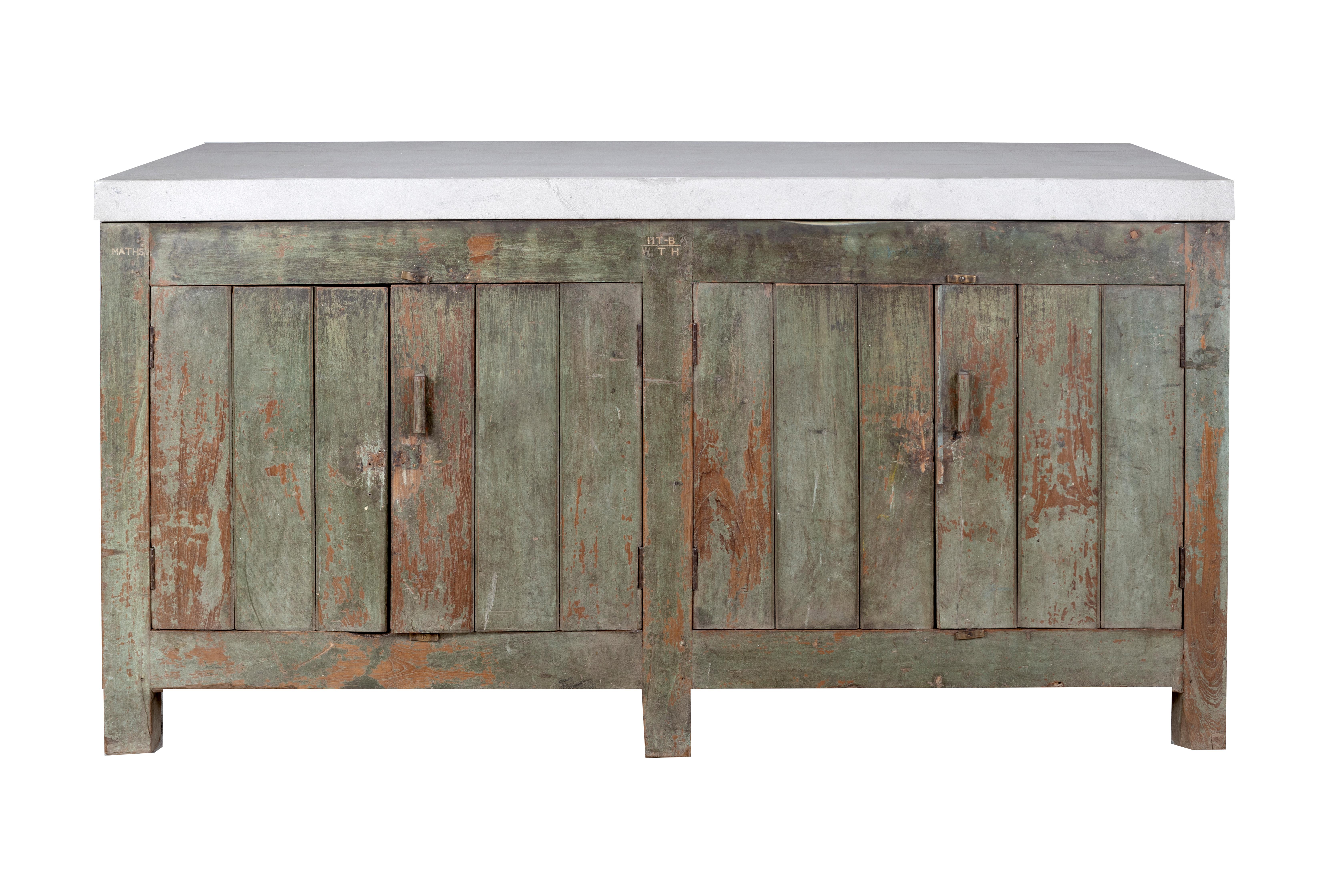 This vintage, distressed French tradesman’s cabinet has a limestone top with storage space inside. With its mid-century, organic modern design, this beautiful piece would be perfect at home in a dining room as a sideboard or as a bar or buffet in