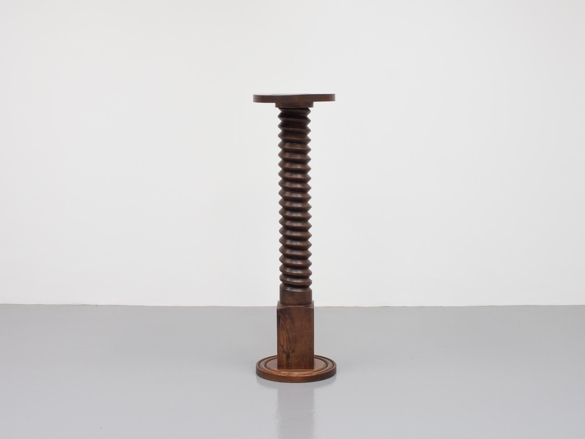 Un socle français avec une tige en forme de colonne tournée, rappelant les dessins de Charles Dudouyt. 

La forme du socle date très probablement du début du XXe siècle, tandis que la colonne à vis tournée est plus ancienne et a probablement été