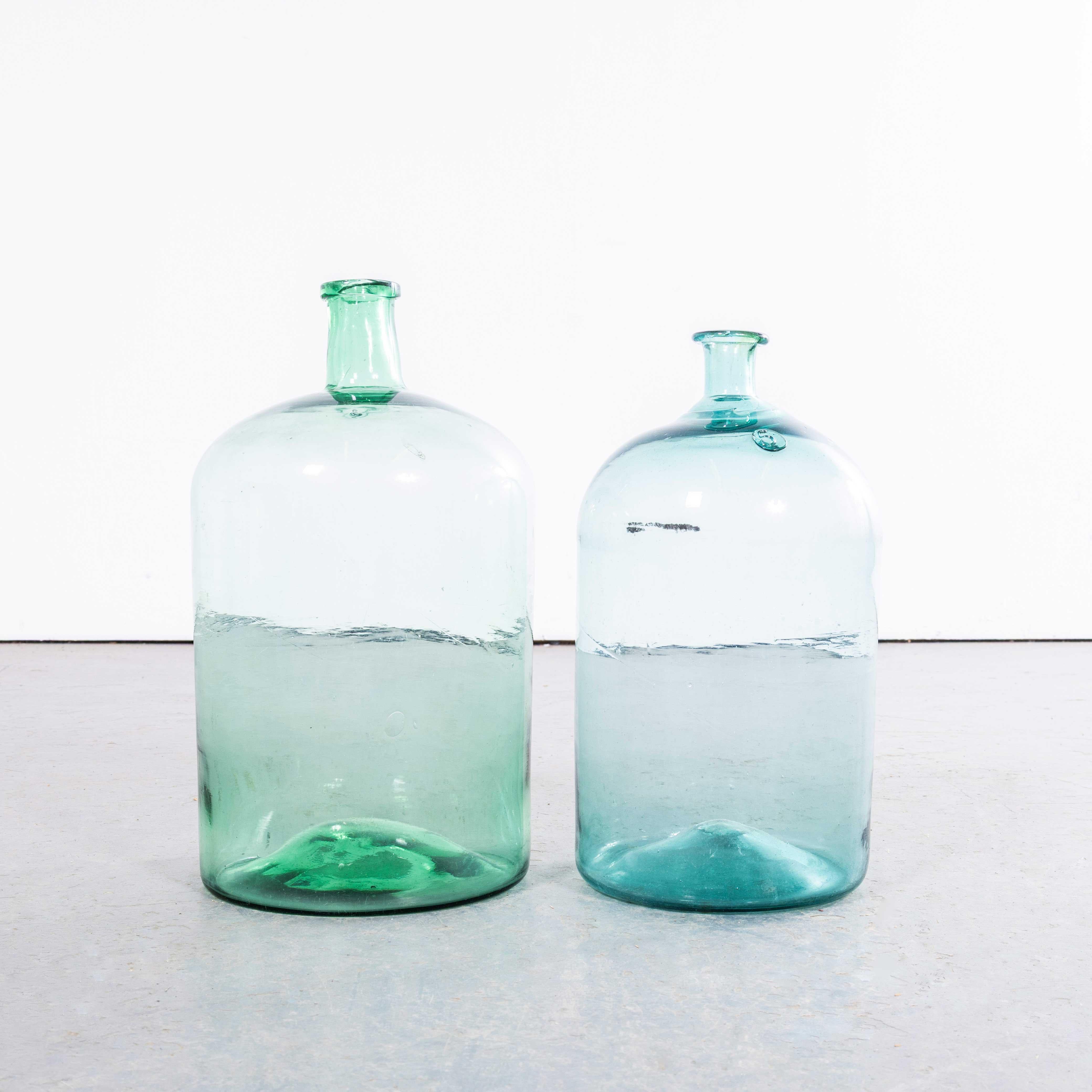 Damigiane francesi d'epoca in vetro turchese e verde bottiglia - Coppia. 

Una coppia di damigiane in vetro soffiato a bocca utilizzate come contenitori tradizionali principalmente per la conservazione e il trasporto del vino. Queste damigiane sono